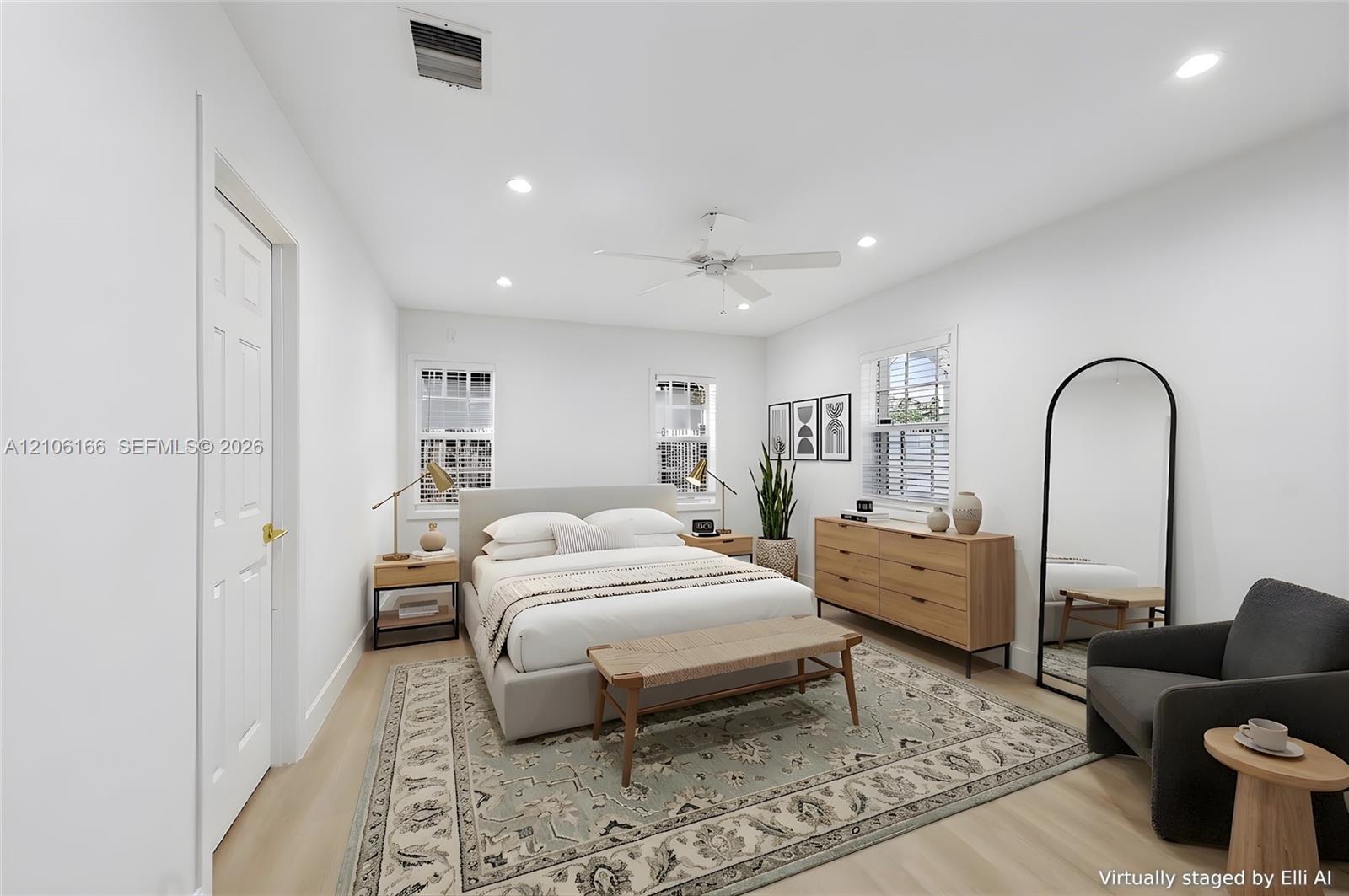 Light-filled room featuring wood-finish flooring, recessed lighting, a white ceiling fan, and three windows with white muntins
