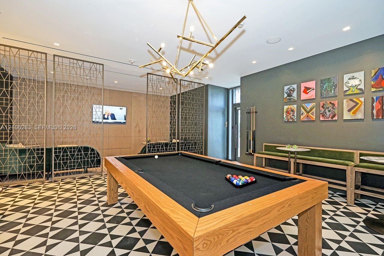 Geometric patterned tile flooring, intricate metal lattice room dividers, custom wood-finish built-in bench seating, and a statement branching chandelier