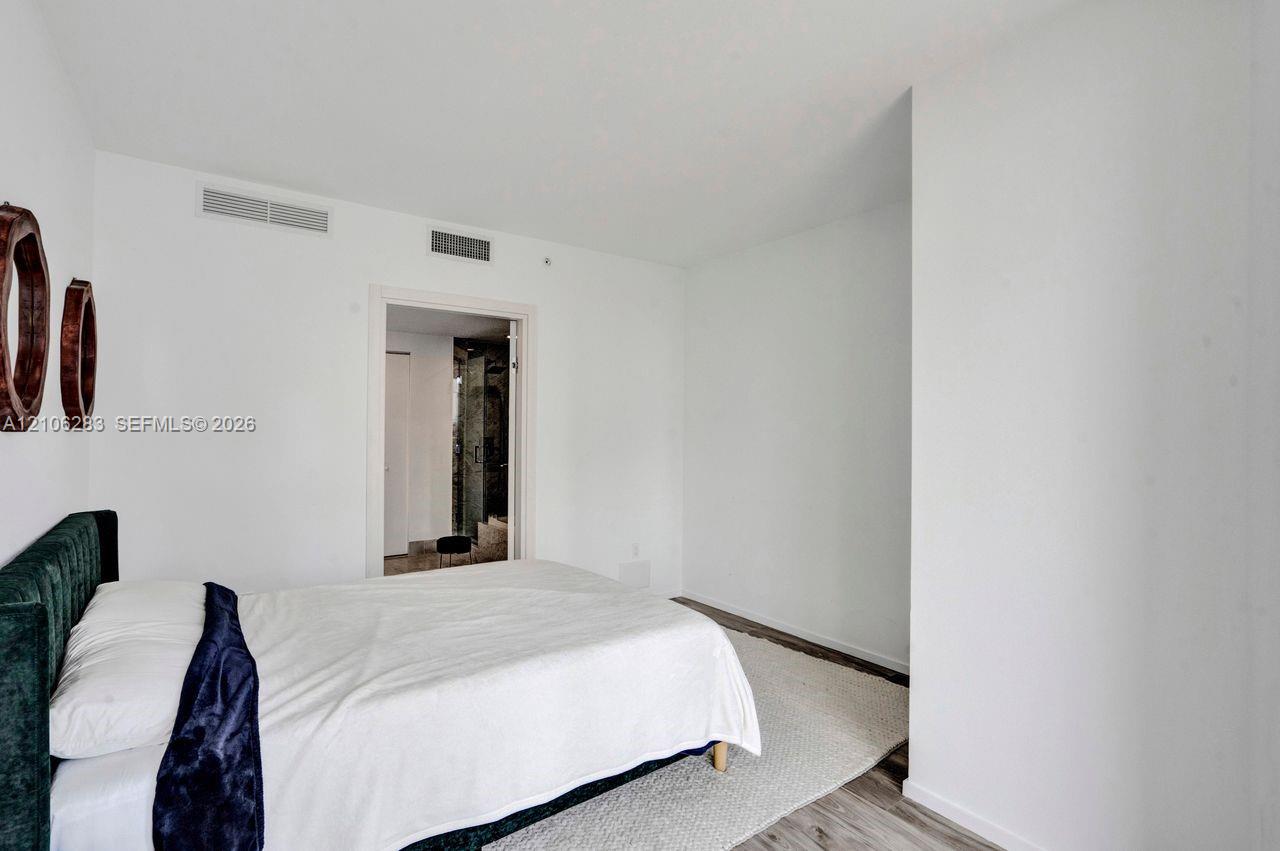 Room featuring white walls and wood-finish flooring