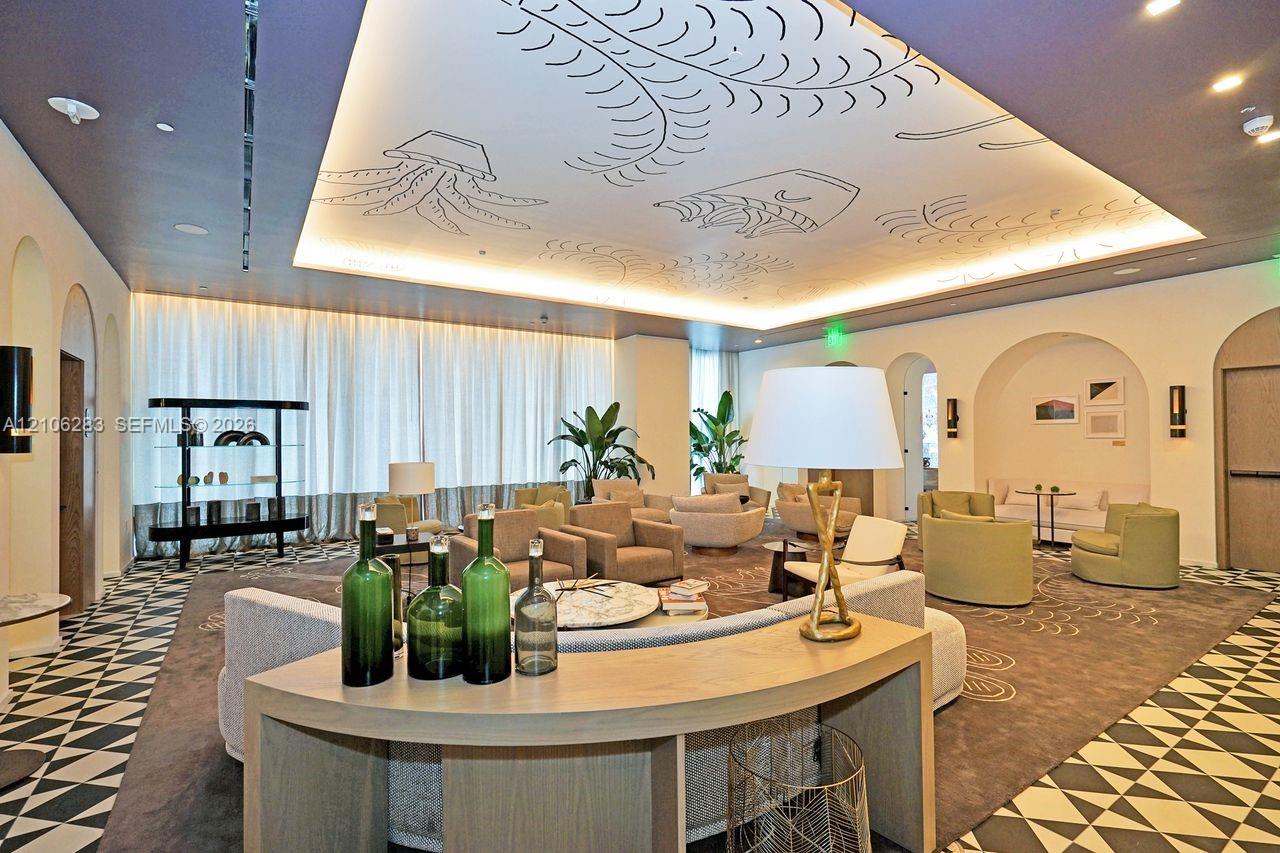 Tray ceiling featuring custom illustrative detailing, recessed lighting, arched wall alcoves, and decorative geometric-patterned flooring