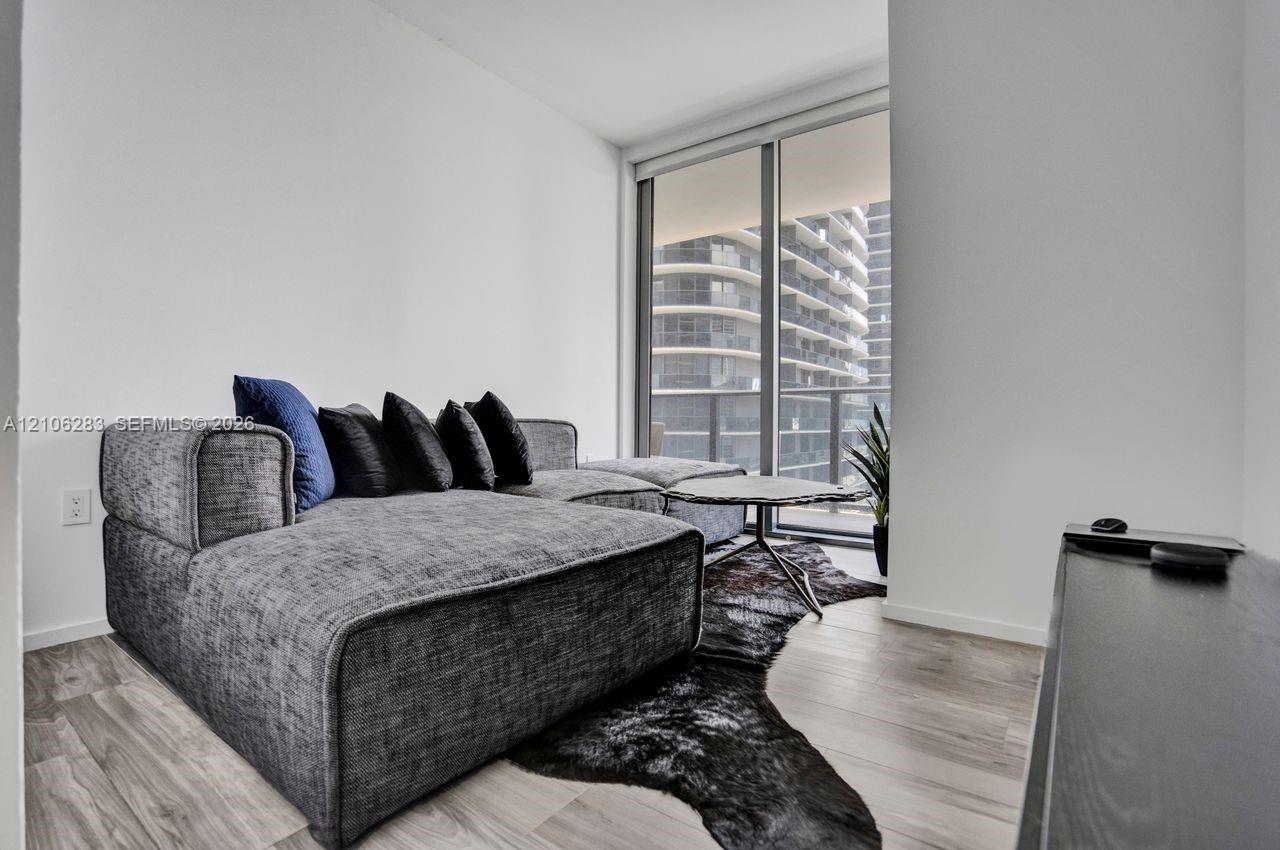 Floor-to-ceiling windows featuring a metal frame and light wood-finish flooring