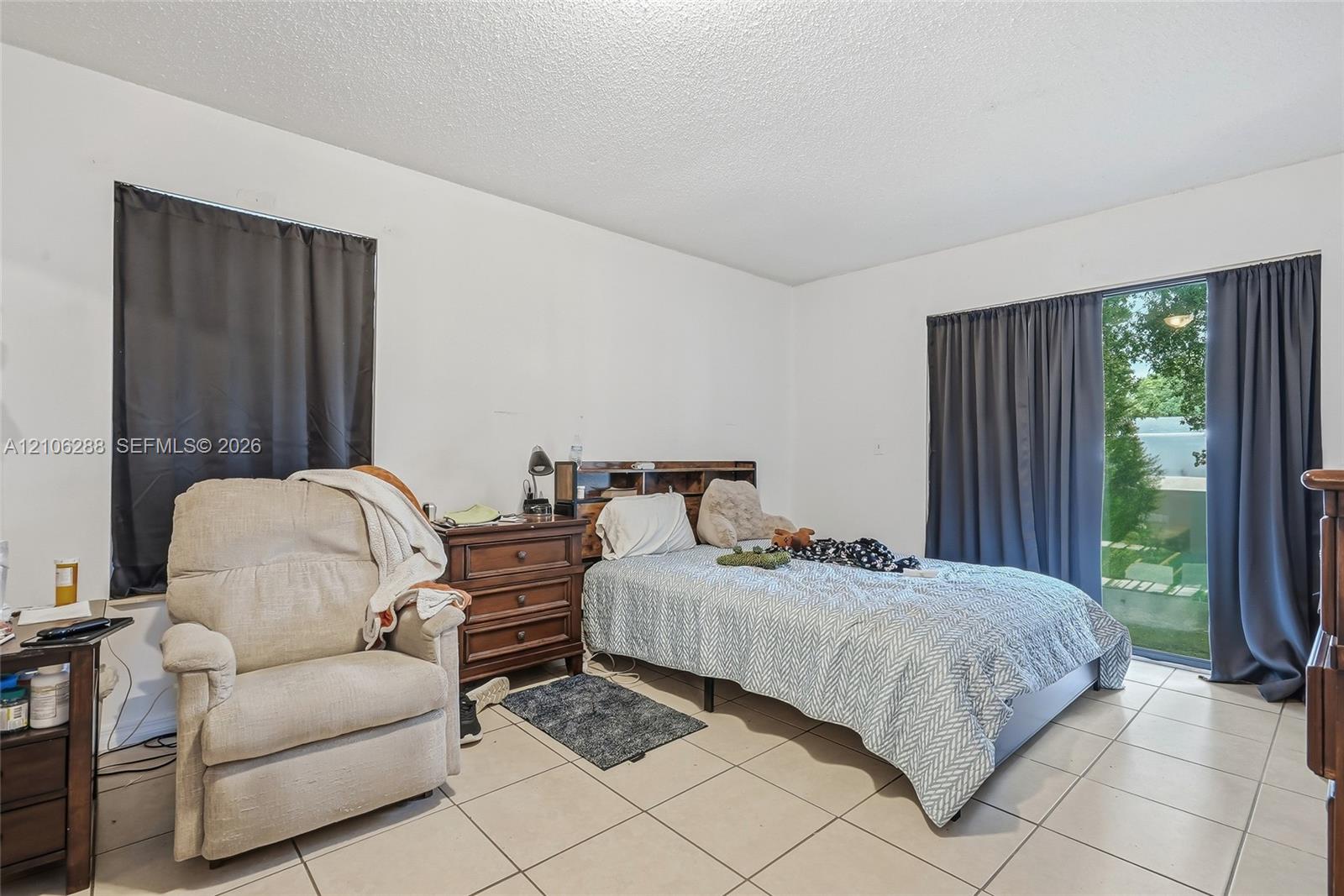 Neutral wall finishes, ceramic tile flooring, and a sliding glass door providing exterior access