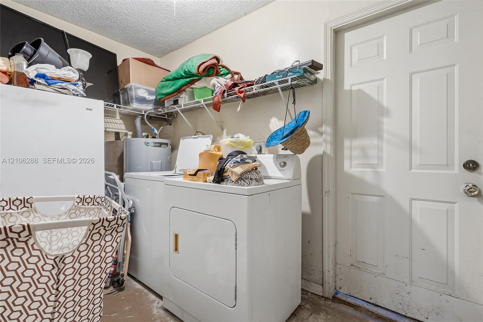 Dedicated utility space featuring a white six-panel door, metal wire shelving, and a water heater