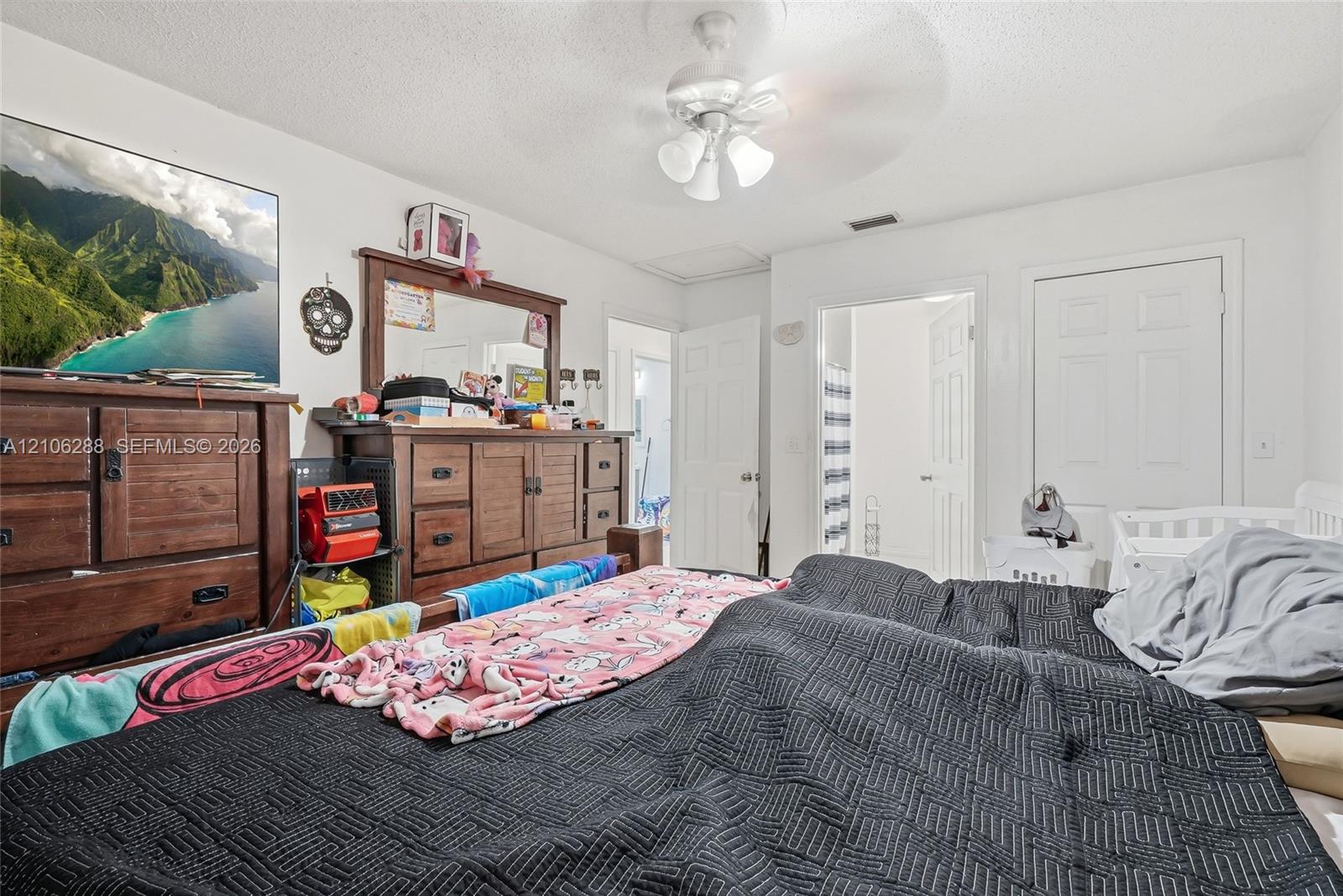 Room featuring white walls, a ceiling fan with integrated lighting, and white six-panel interior doors