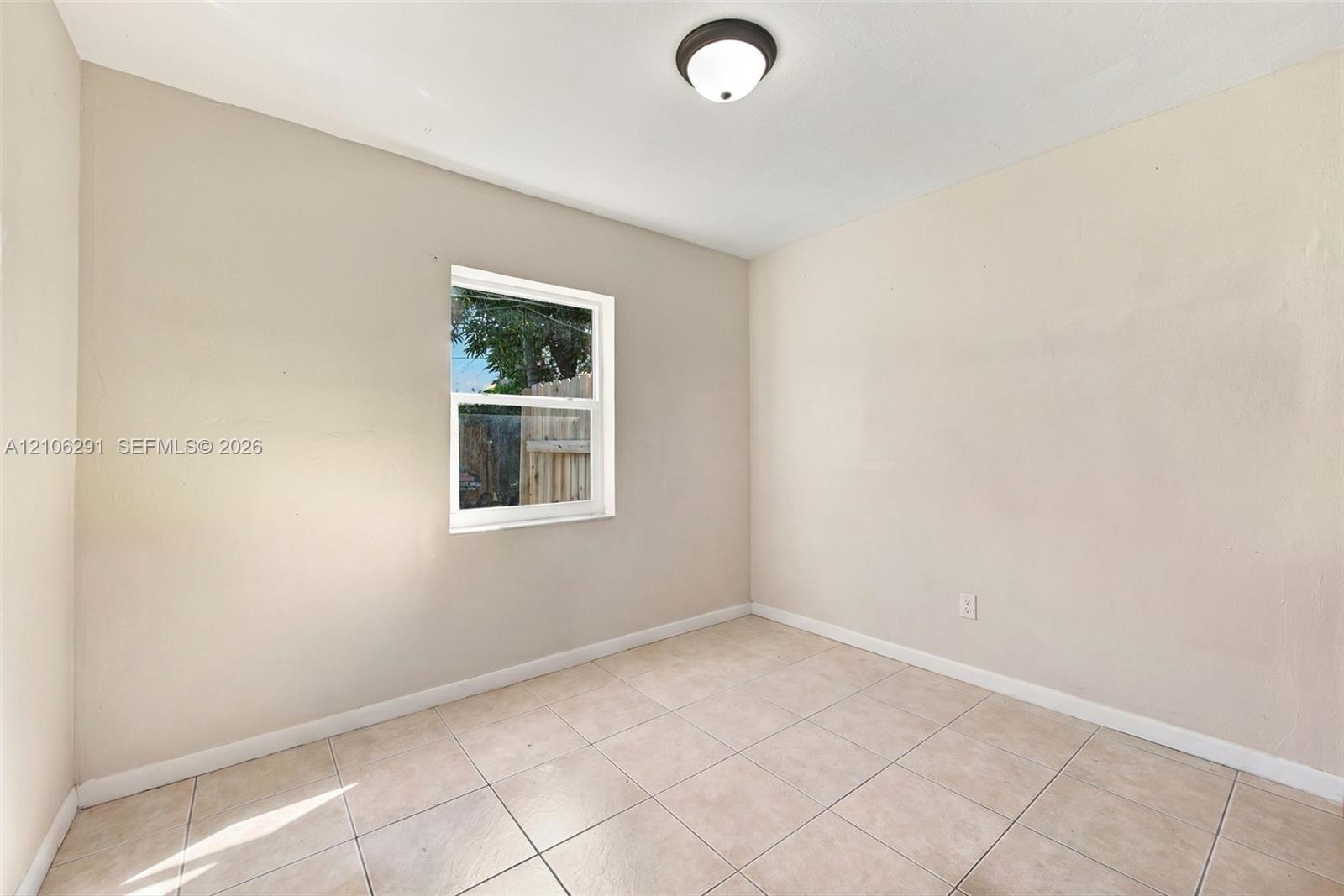 Neutral wall finish, ceramic tile flooring, and flush-mount ceiling light fixture