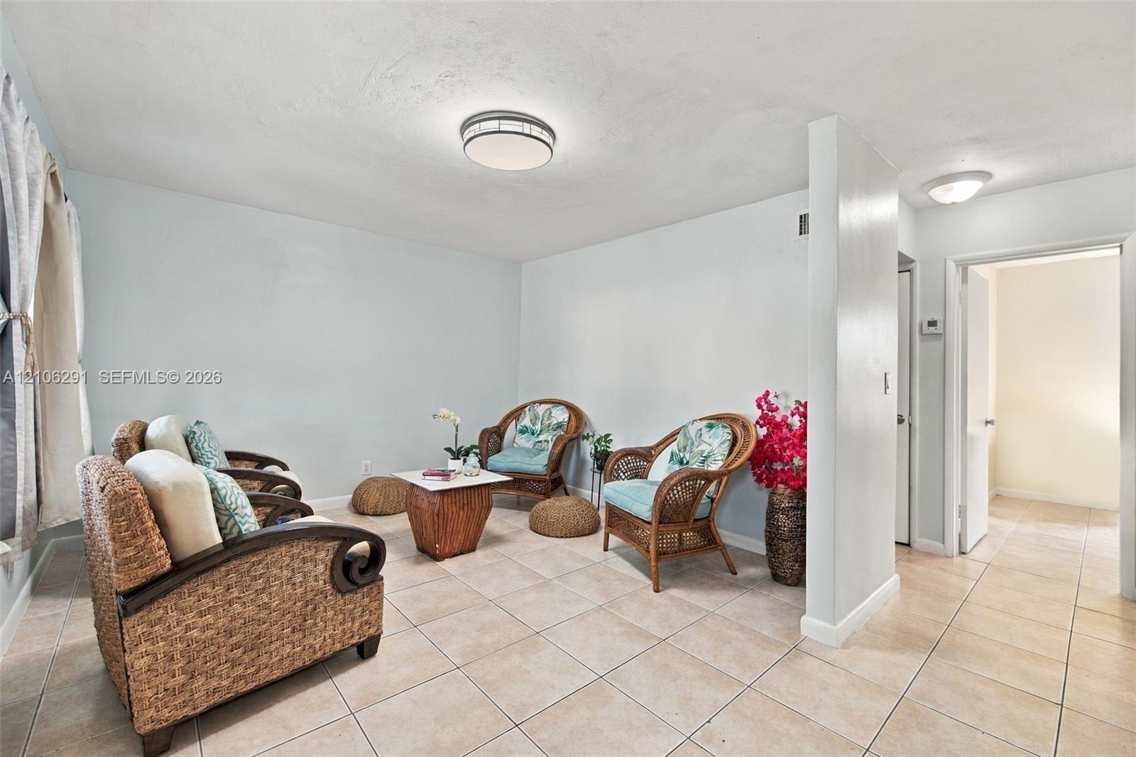 Neutral ceramic tile flooring, rounded flush-mount ceiling lighting fixtures, and solid-core interior doors