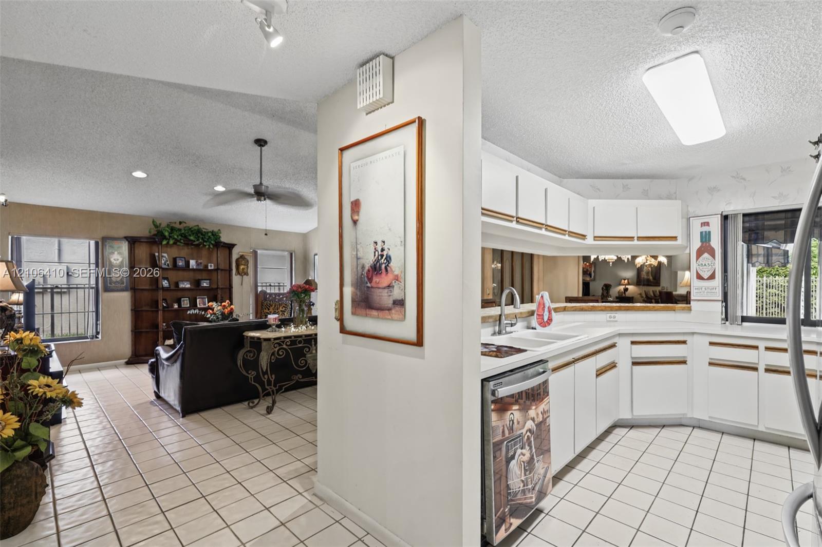 Kitchen featuring white cabinetry, ceramic tile flooring, and integrated lighting