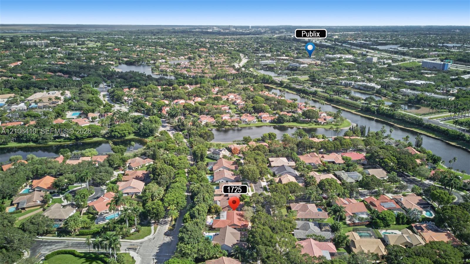 Aerial perspective highlighting mature tree canopy, neighborhood lakes, and established residential landscaping