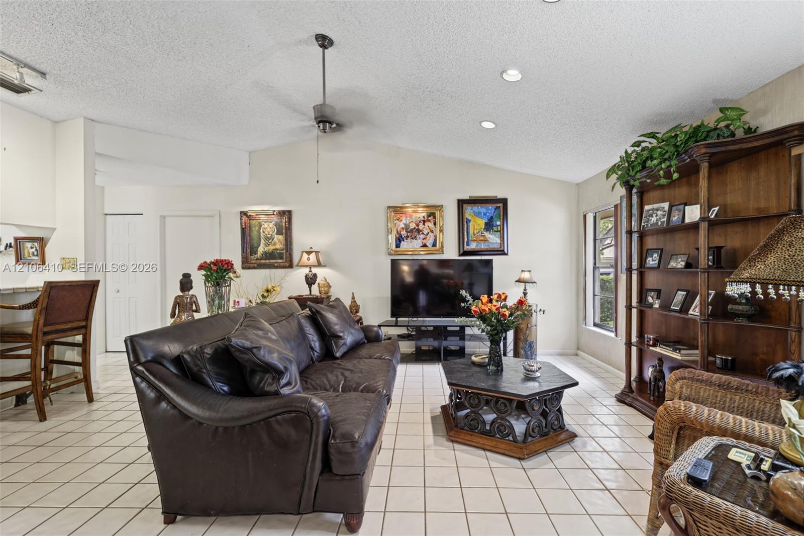 Living room featuring vaulted ceilings, recessed lighting, a ceiling fan, and ceramic tile flooring