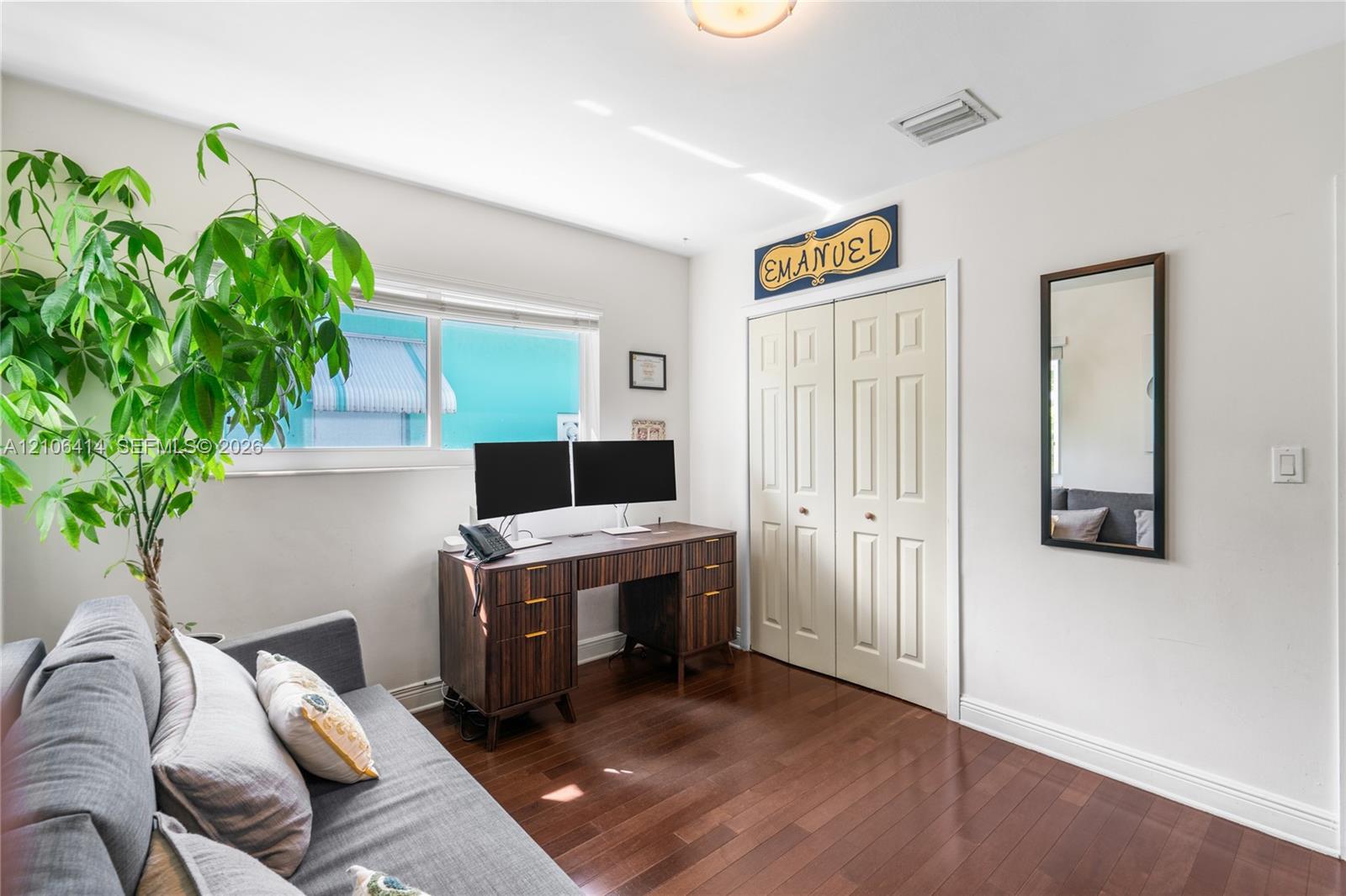 Wood-finish flooring, dual-panel closet doors, and natural light via horizontal windows