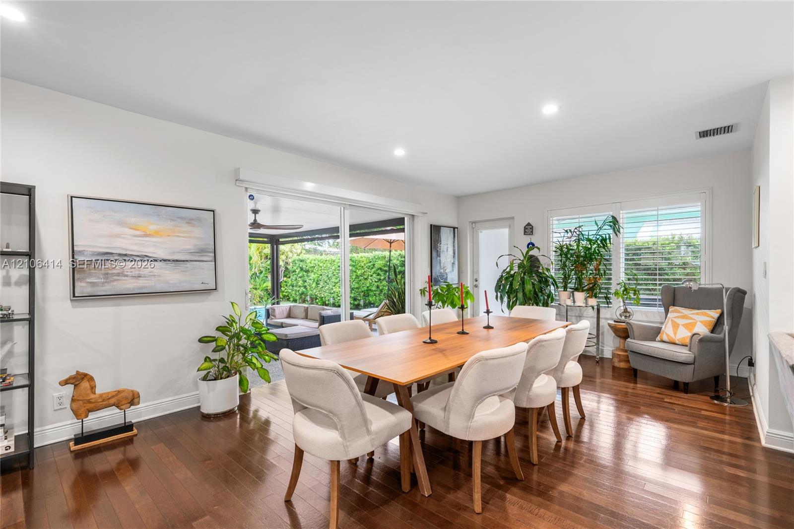 Dining area featuring dark wood-finish flooring, recessed lighting, and large sliding glass doors providing access to the exterior