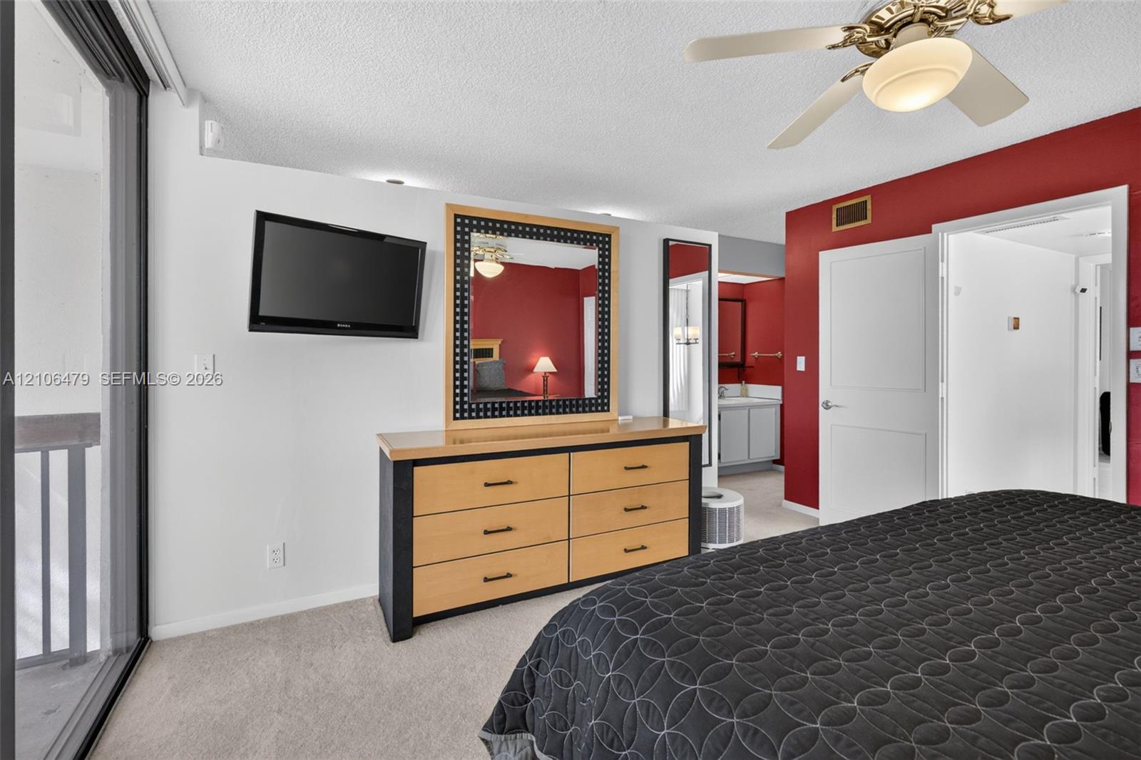Wall-to-wall carpeting, ceiling fan with integrated lighting, glass sliding door, and neutral wall tones