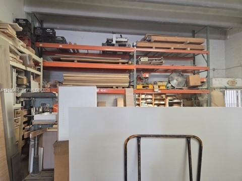 Industrial-style workspace featuring high ceilings, structural steel racking systems, and integrated open storage shelving