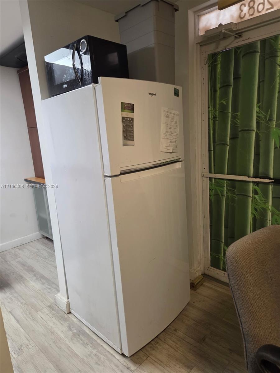 White top-freezer refrigerator and wood-finish flooring