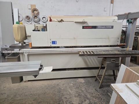 Industrial-grade SCM Olimpic K208 edgebanding machine featuring a heavy-duty metal frame, integrated control panel, and roller feed system