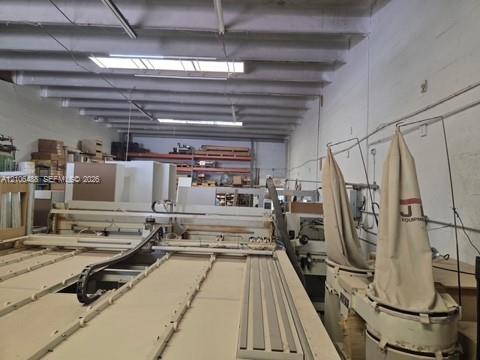 Industrial workspace featuring high, exposed-beam ceilings, integrated dust collection systems, and open-span floor plan