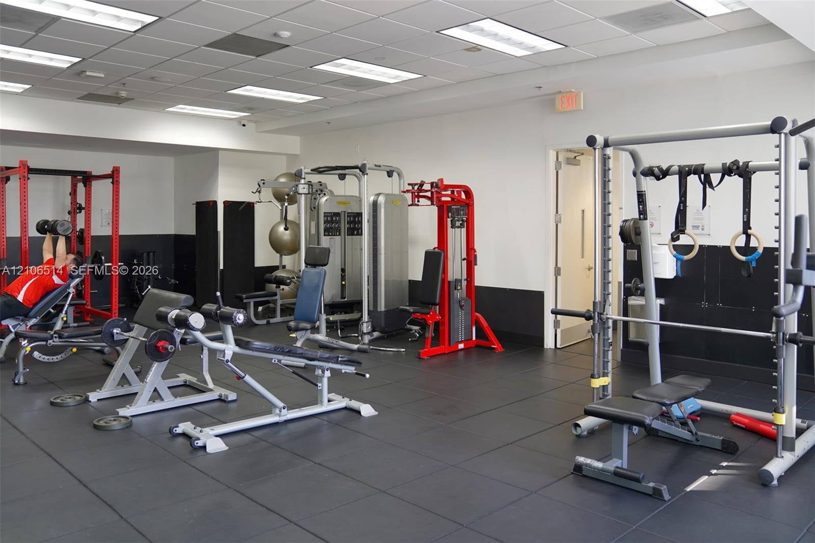 Fitness center featuring modular flooring, recessed lighting, and a selection of integrated strength training equipment