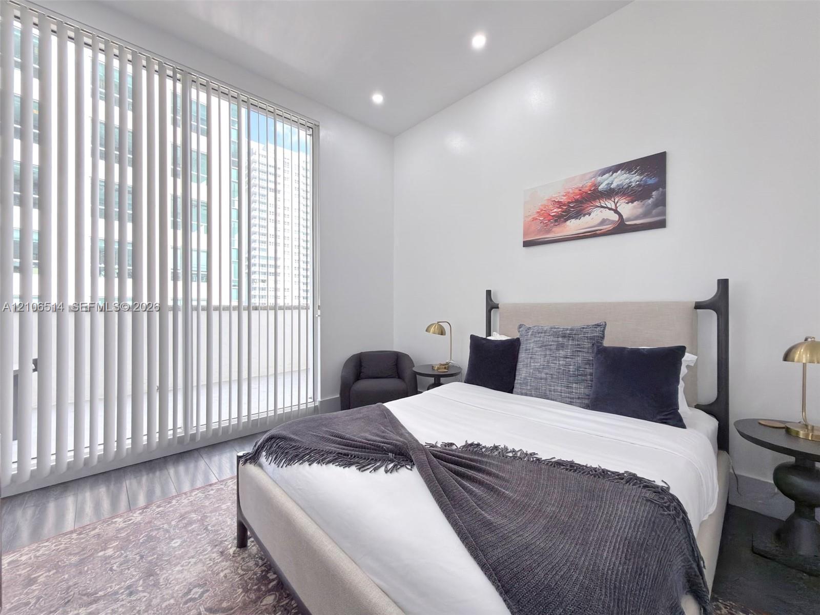 Floor-to-ceiling vertical blinds, recessed lighting, and dark-toned flooring