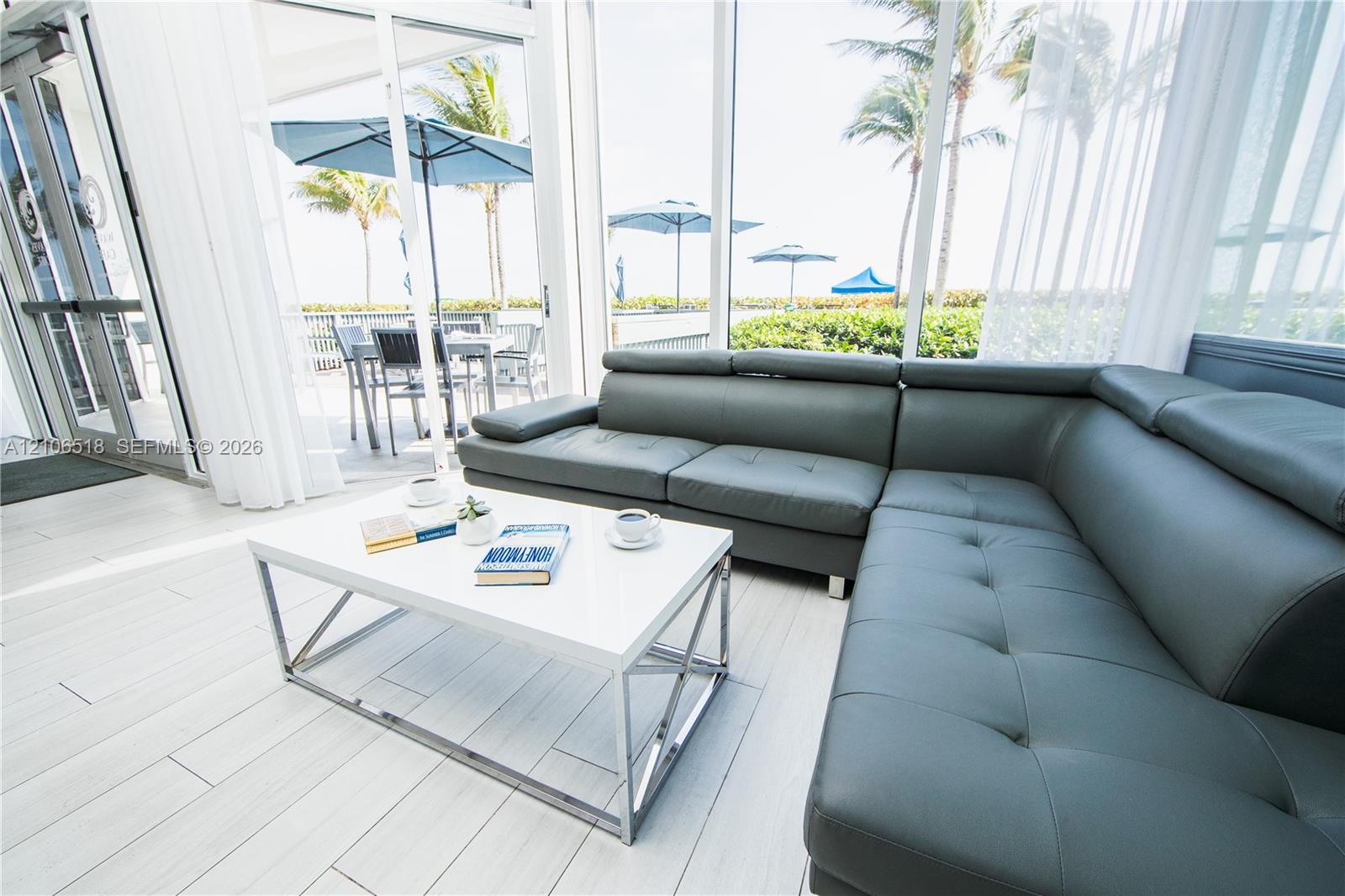 Enclosed patio featuring floor-to-ceiling glass paneling, light-toned tile flooring, and access to an exterior terrace