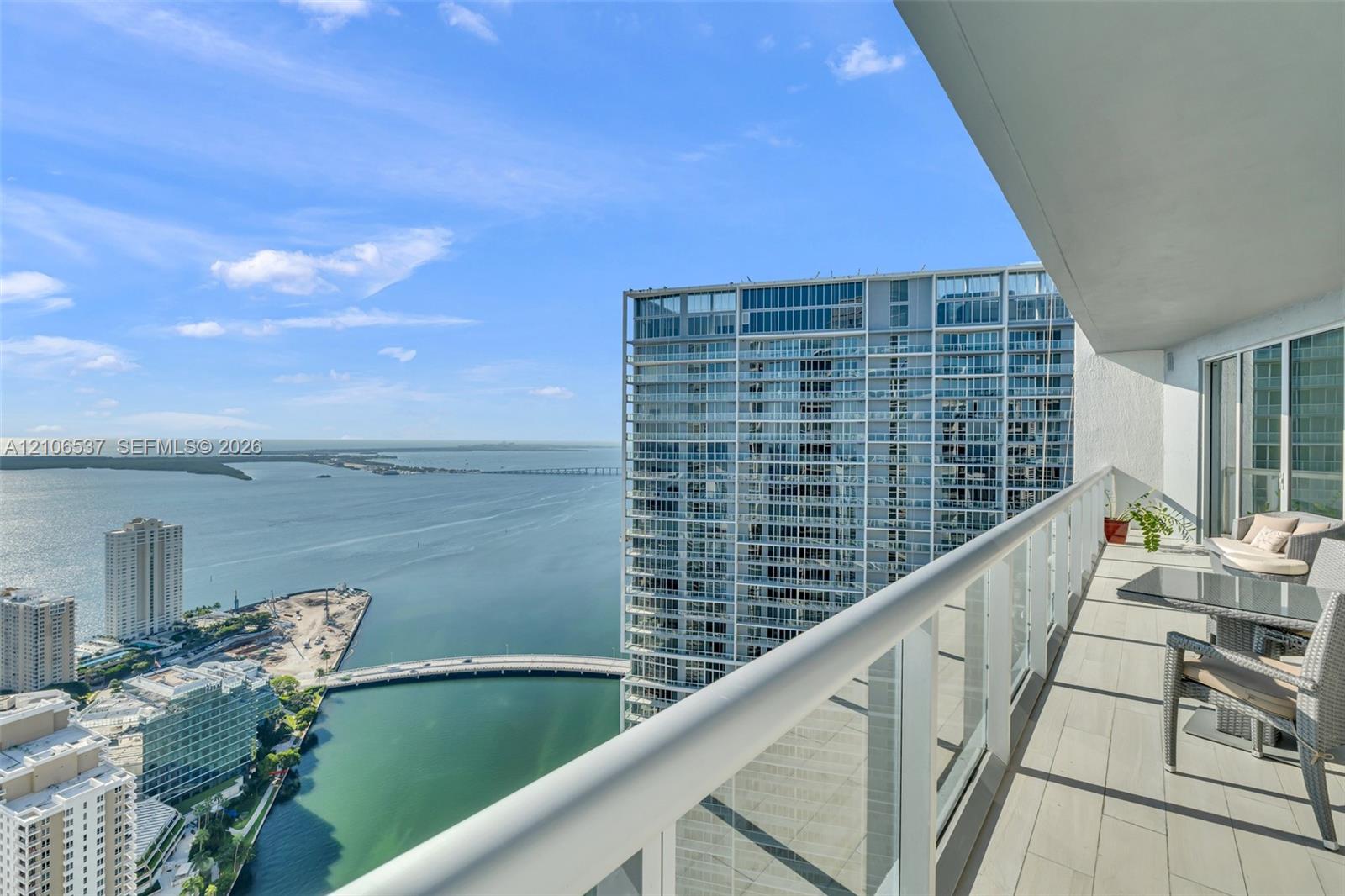 Covered balcony with large-format tile flooring and a glass-paneled railing