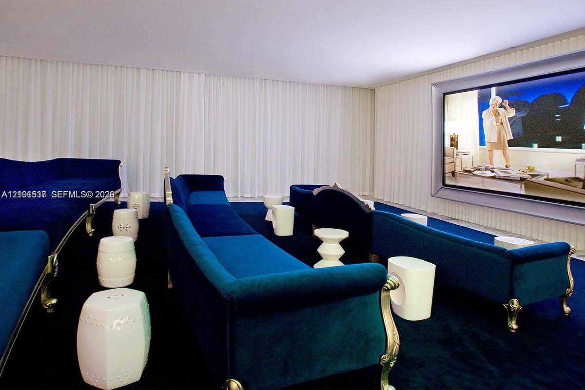 Media room featuring a recessed wall-mounted screen, floor-to-ceiling drapery, and wall-to-wall carpeting