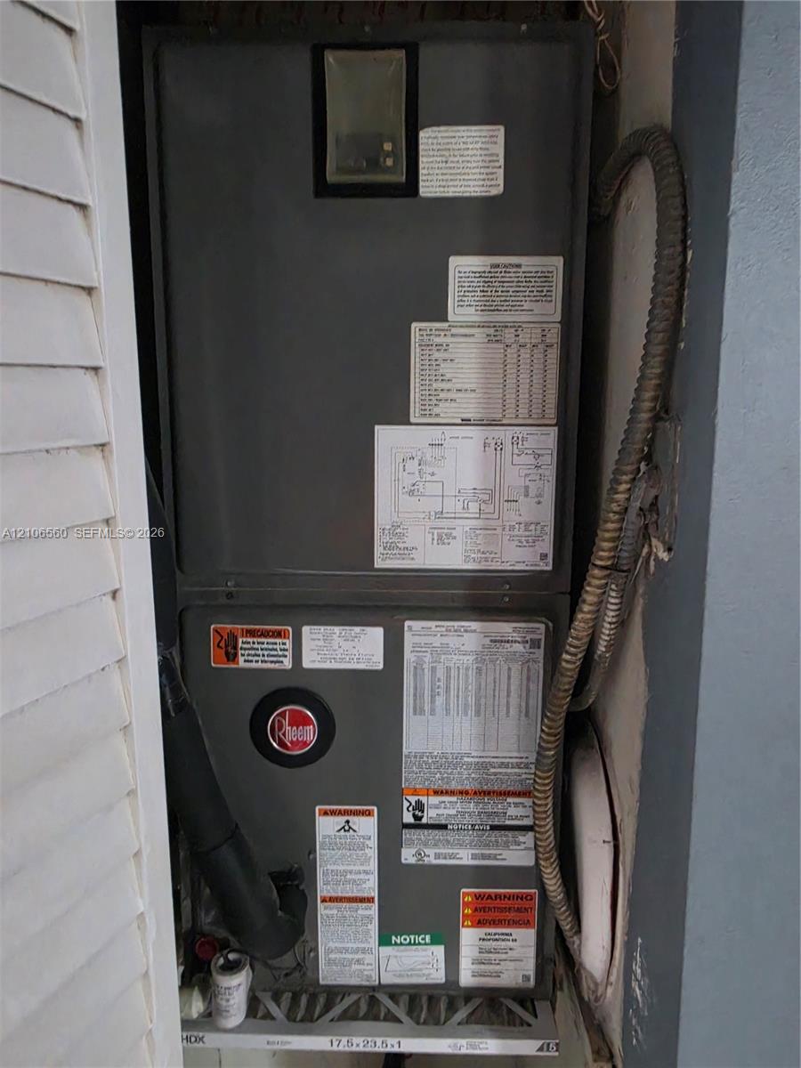 Rheem HVAC system featuring an integrated metallic cabinet, diagnostic information placards, and accessible air filtration housing