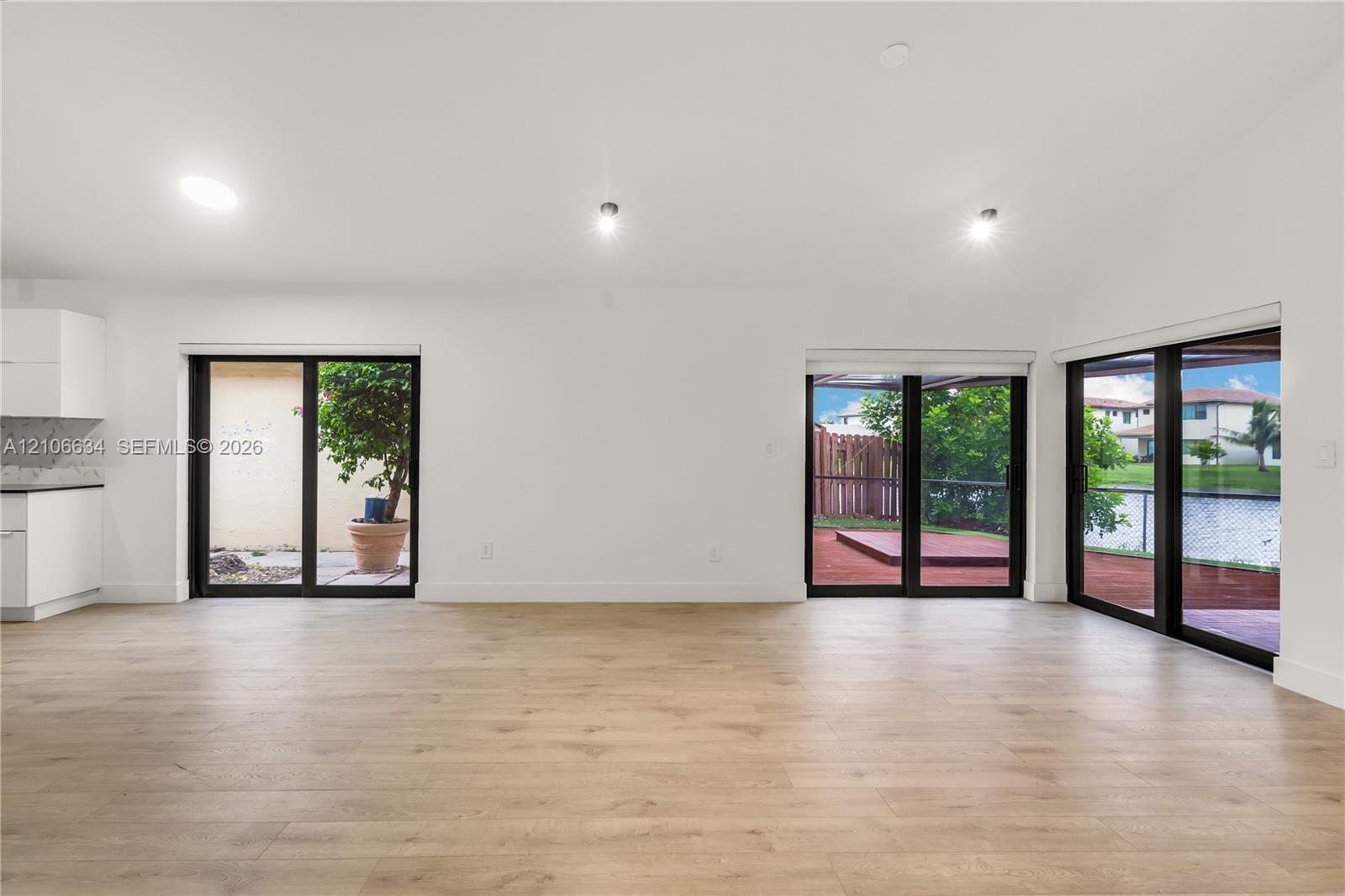 Open-concept interior, recessed lighting multiple sliding glass doors providing outdoor access
