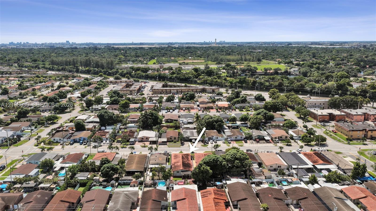 Aerial perspective of a residential property featuring a pitched roof, rear outdoor area, and established shade trees