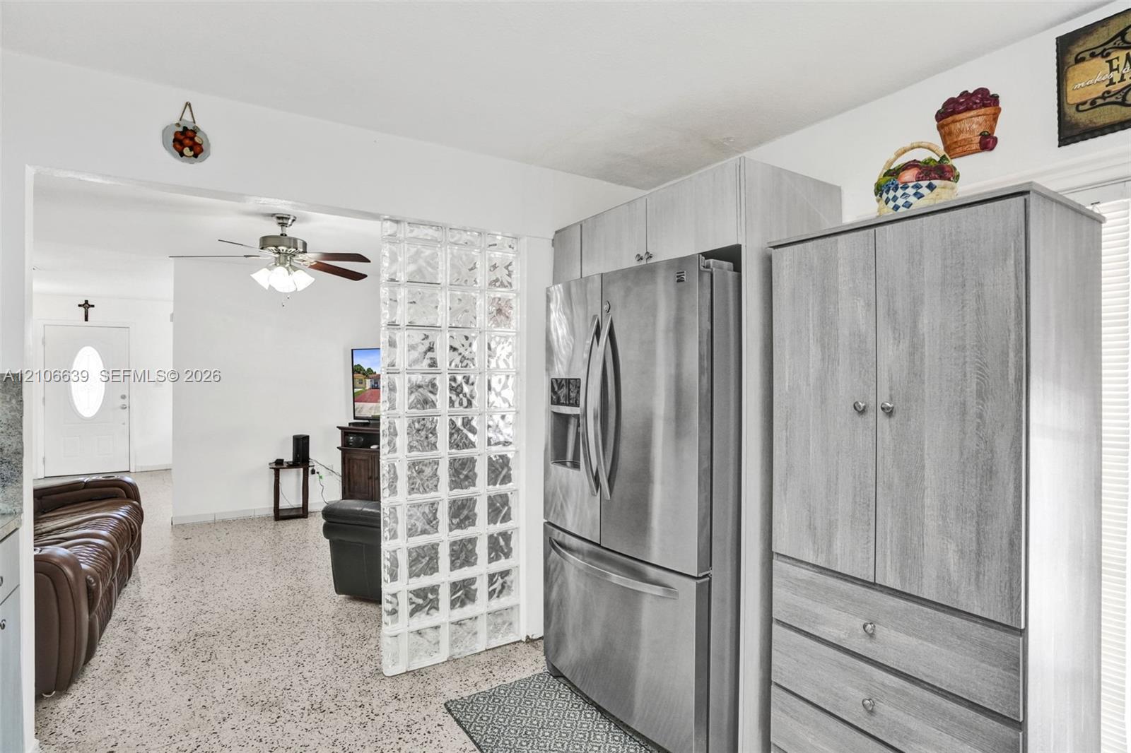 Glass block partition, stainless steel french-door refrigerator, and wood-finish cabinetry
