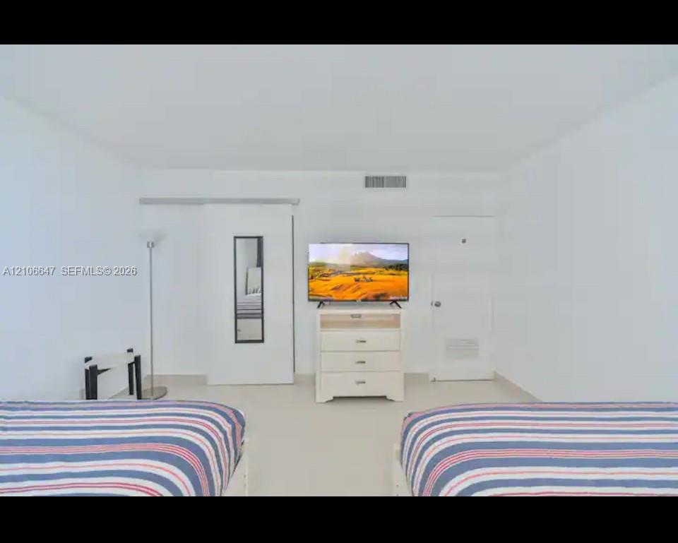 Room featuring neutral wall-to-wall flooring, a sliding door panel, and a solid-core interior door