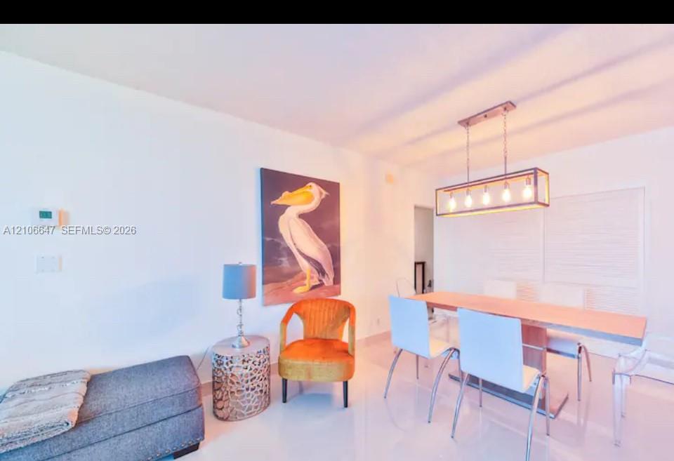 Open interior space featuring light-toned tile flooring and a rectangular metal-frame multi-bulb pendant light fixture