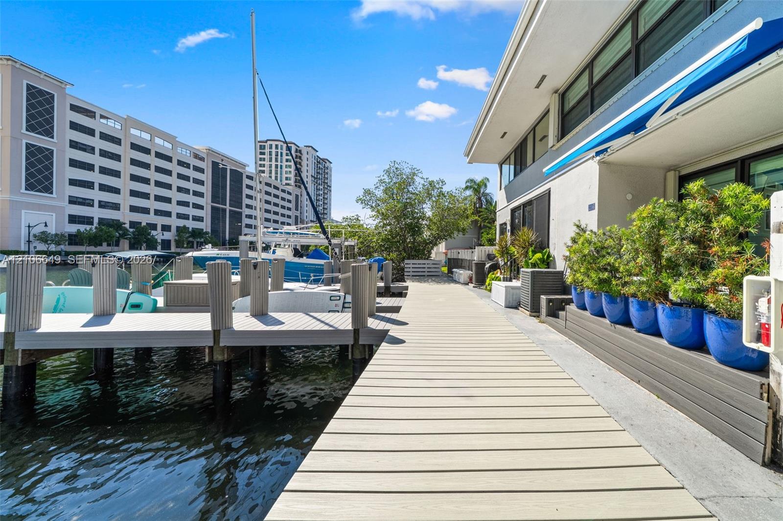 Waterfront property featuring a private composite dock, direct water access, and exterior stairs with integrated landscaping