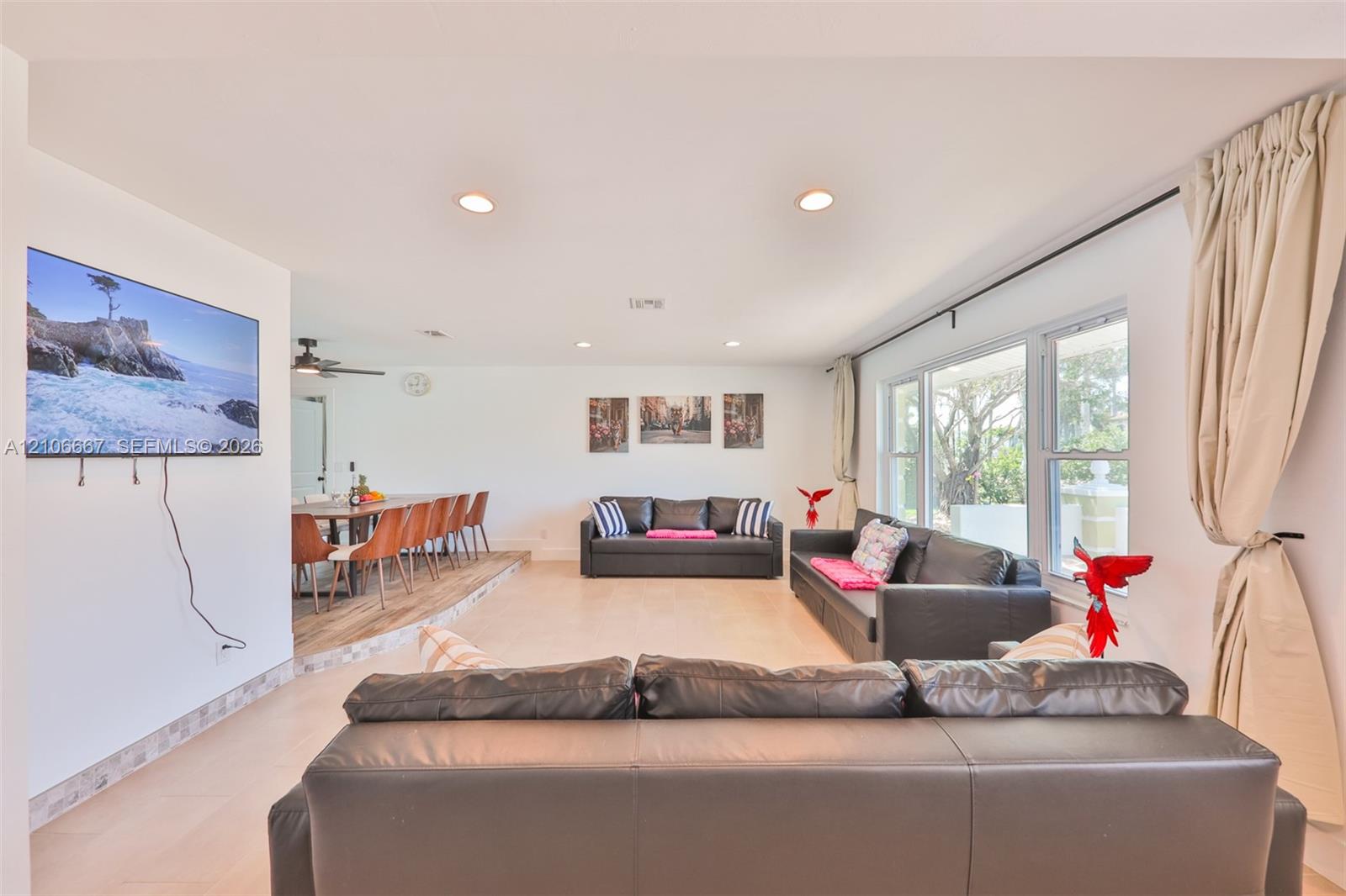 Open-concept interior featuring recessed lighting, light-toned flooring, multi-pane windows, and a raised platform area Open-concept interior featuring recessed lighting, light-toned flooring, multi-pane windows, and a raised platform area