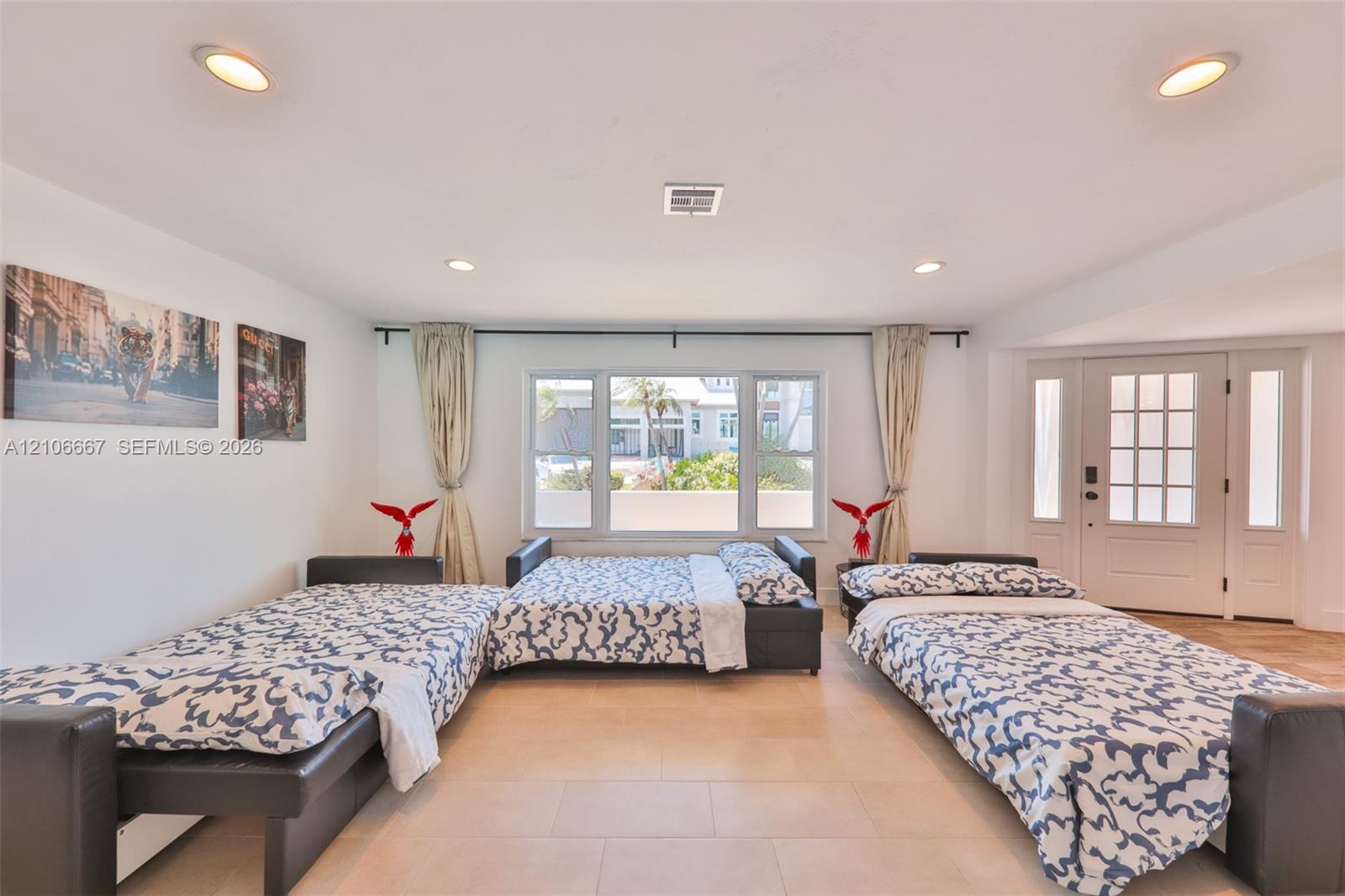 Large-format tile flooring, recessed ceiling lighting, and a multi-pane entry door with sidelights