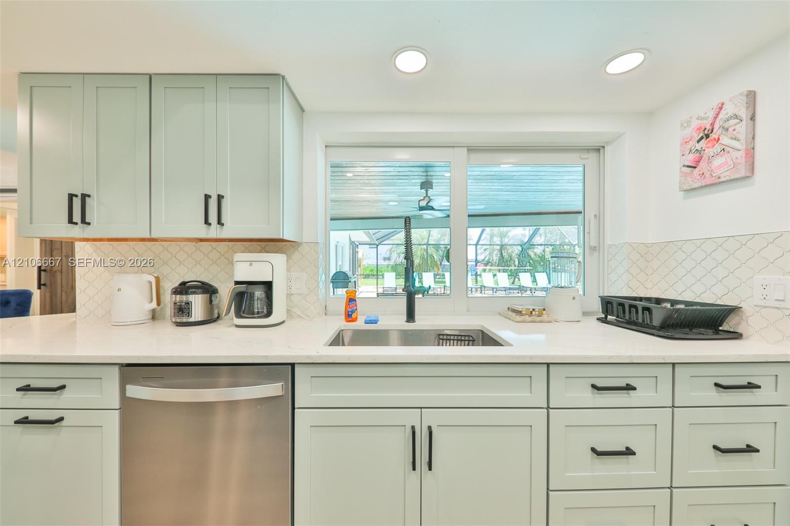 Kitchen featuring soft-green cabinetry, white countertops, recessed lighting, a stainless steel dishwasher, and a diamond-patterned backsplash