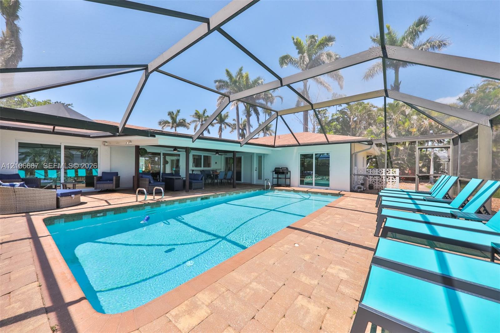 Screen-enclosed swimming pool with a paver patio and covered lanai