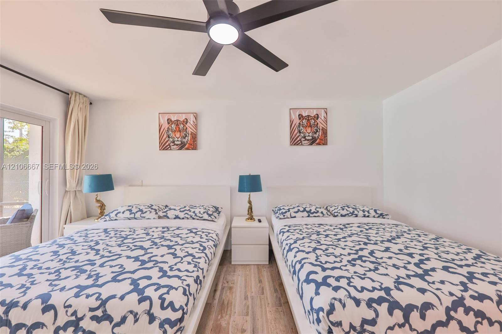 Wood-finish flooring, central ceiling fan with integrated lighting, and sliding glass door