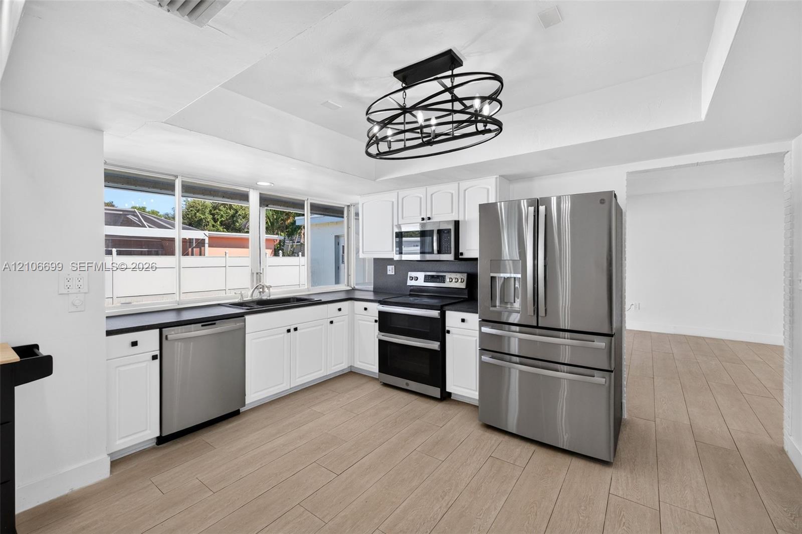Open concept kitchen w/ updated plank wood look tile, stainless appliances approx 2020