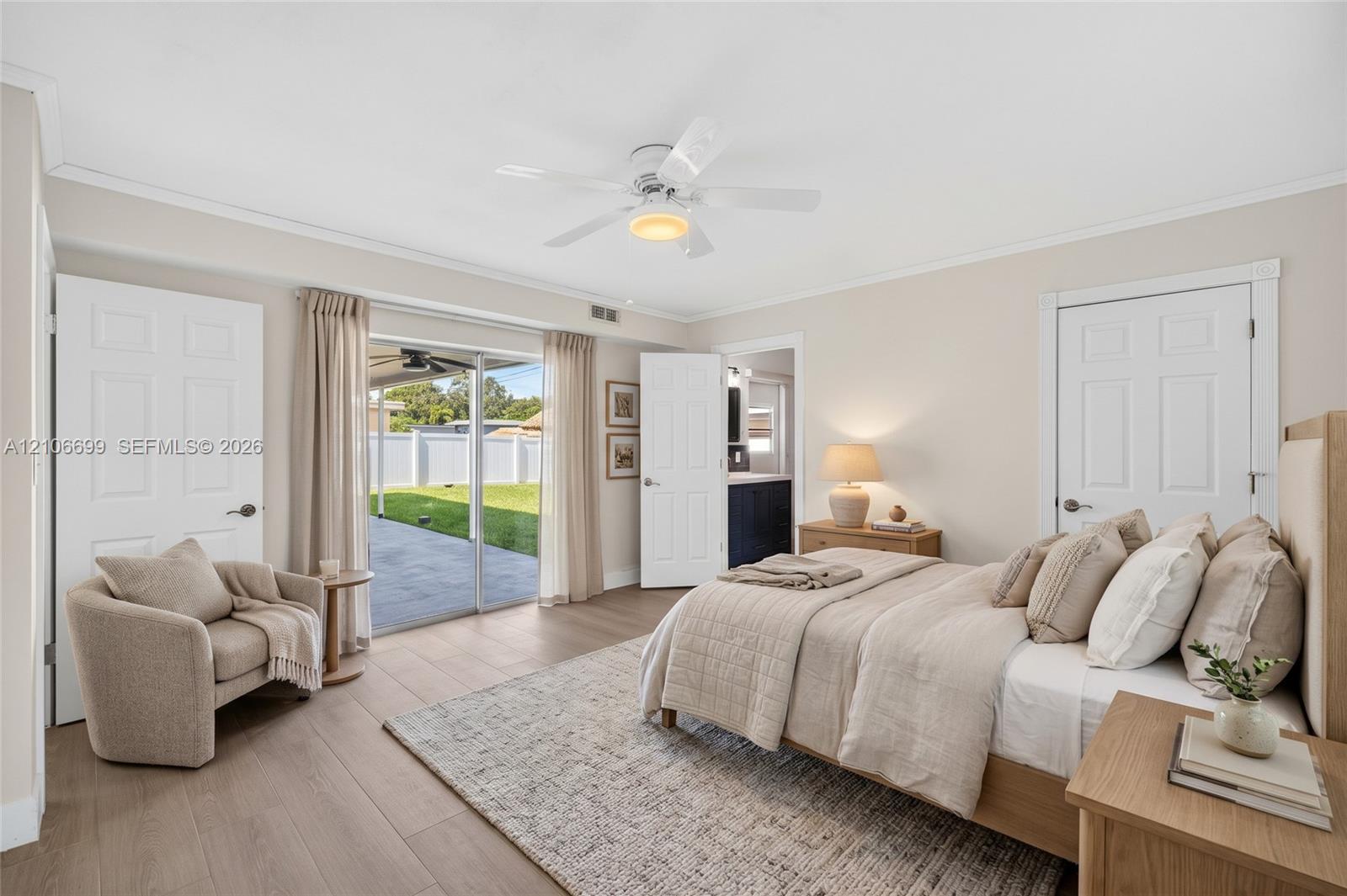 Primary bedroom w/ walk in closet w/ built-ins, en suite bathroom leading to backyard w/ new plank wood look tile