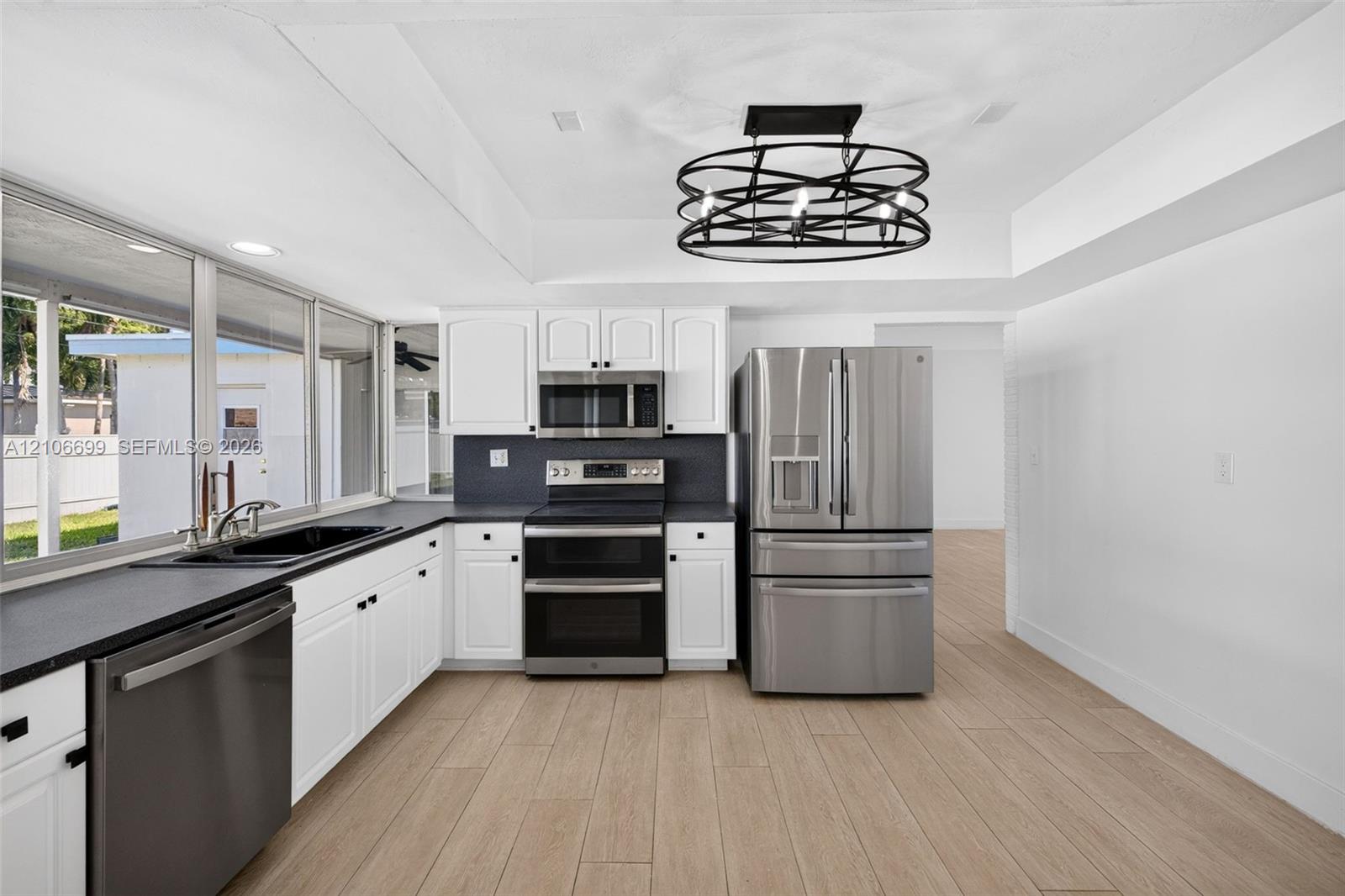 Open concept kitchen w/ updated plank wood look tile, stainless appliances approx 2020