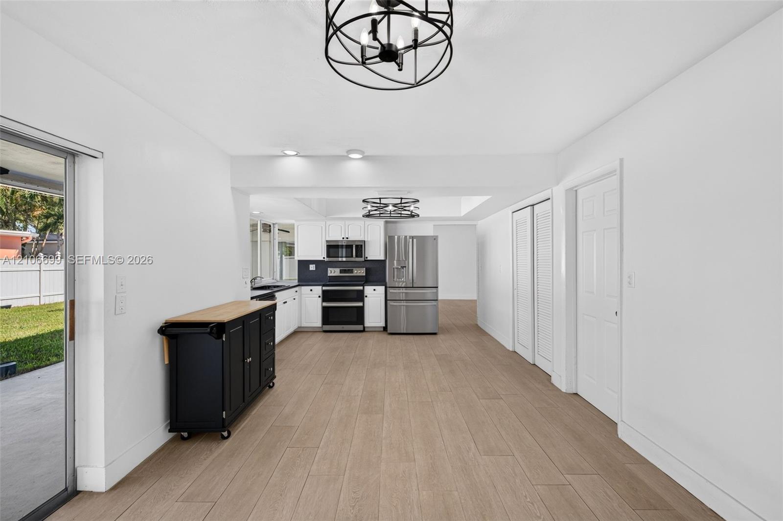 Open concept kitchen w/ updated plank wood look tile, stainless appliances approx 2020