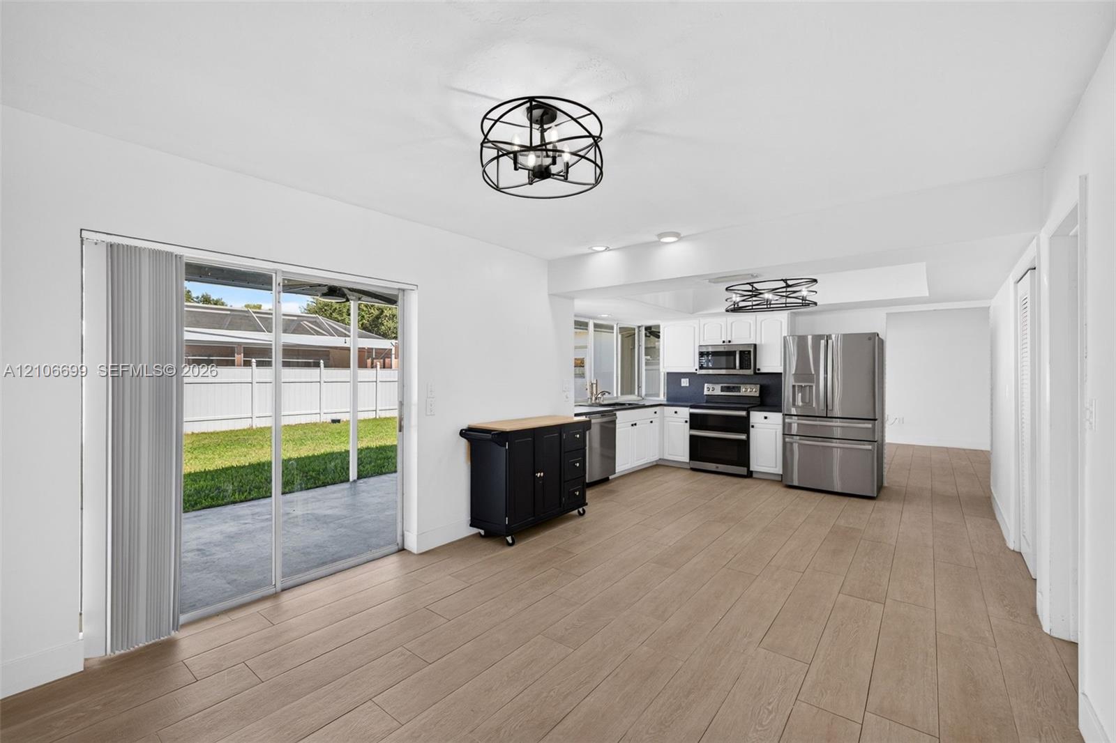 Open concept kitchen w/ updated plank wood look tile, stainless appliances approx 2020