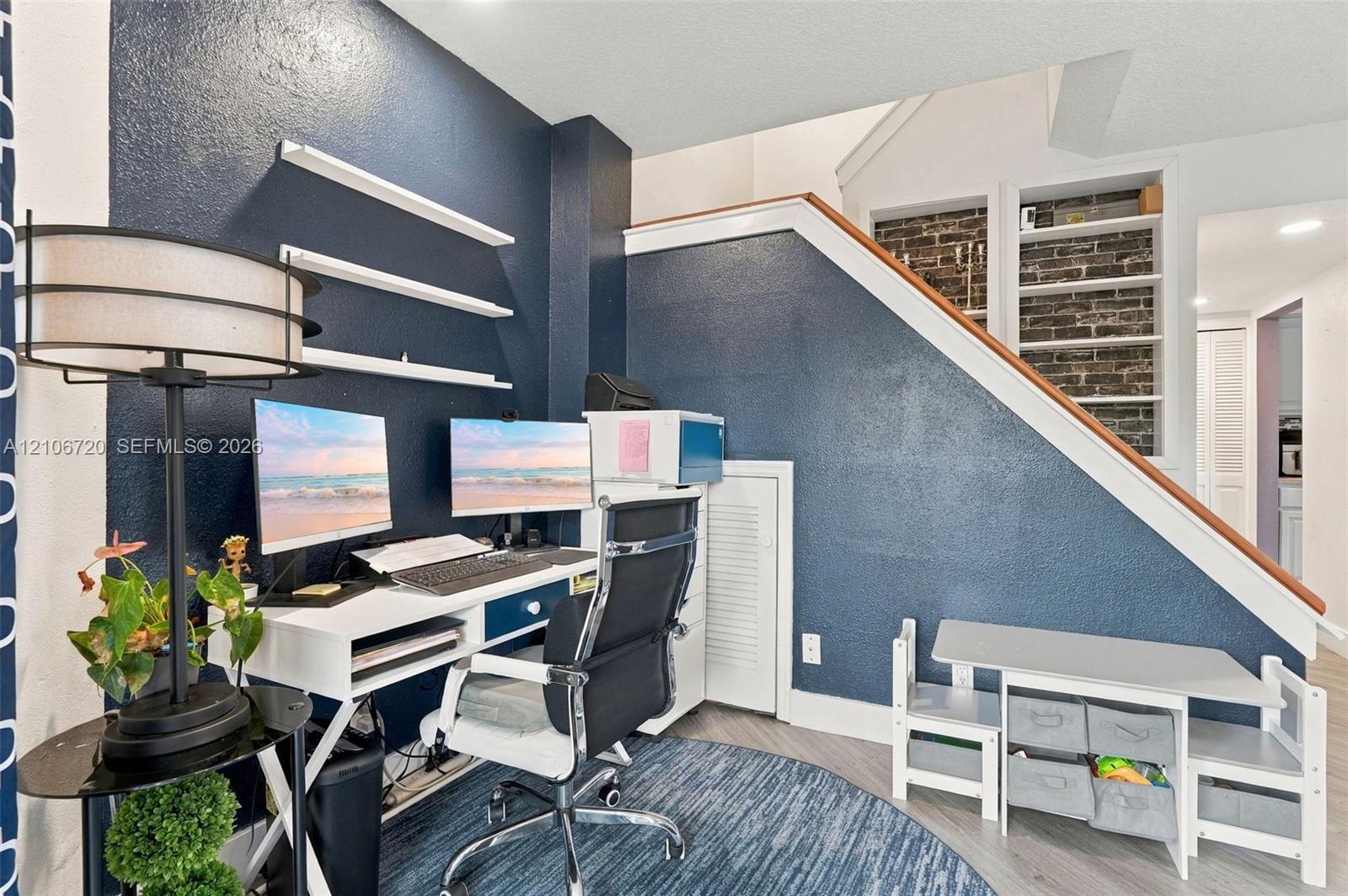 Built-in shelving, exposed brick detail, and wood-finish flooring