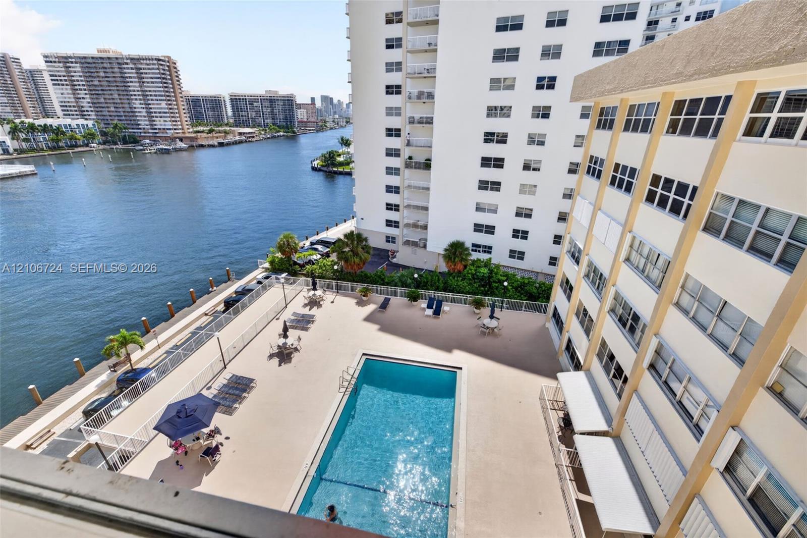 Waterfront swimming pool with concrete deck and metal perimeter fencing