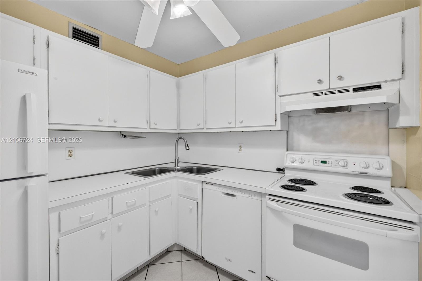 Kitchen featuring white cabinetry, solid-surface countertops, dual-basin sink with a gooseneck faucet, integrated dishwasher, and electric range
