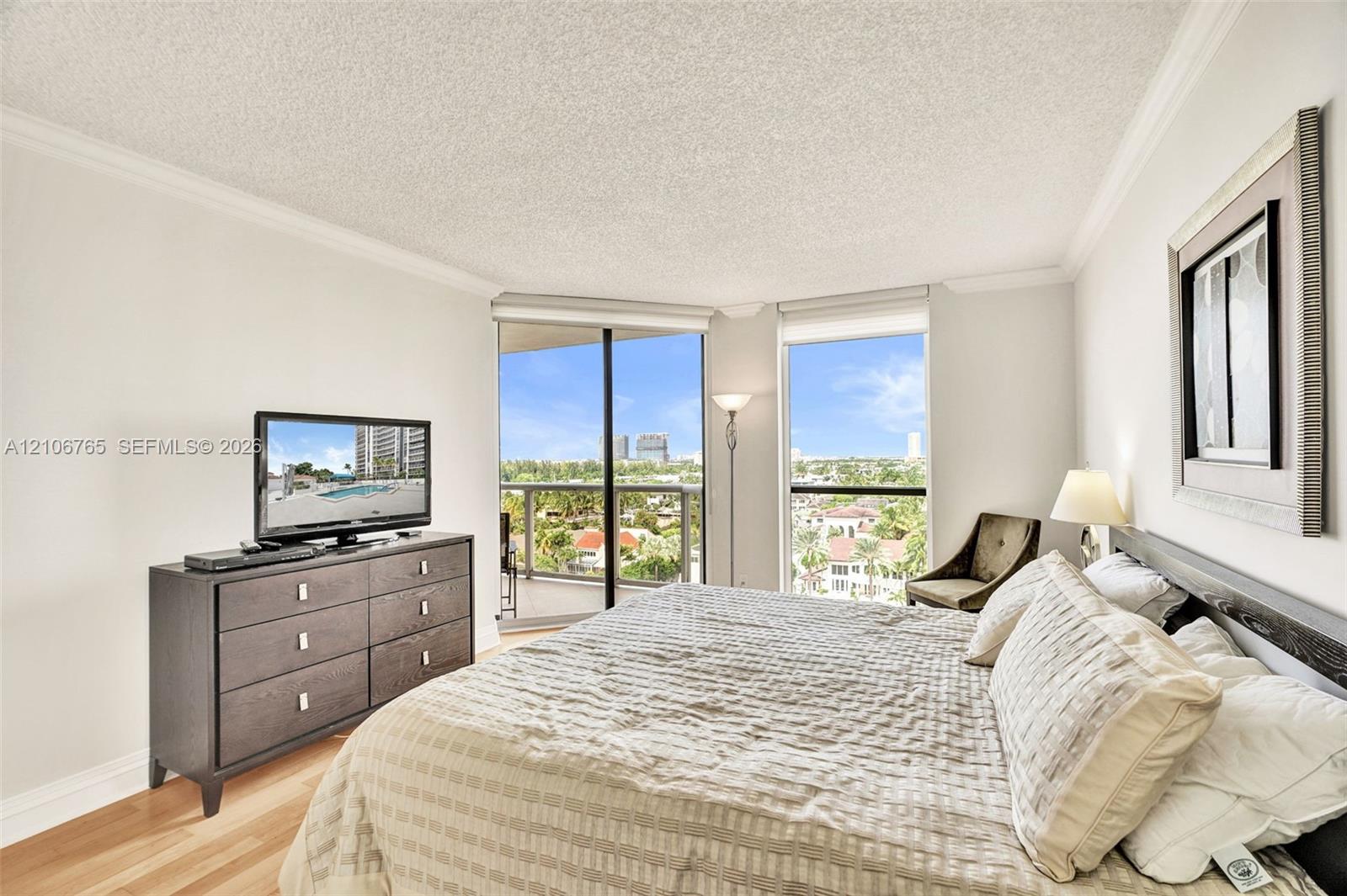 Floor-to-ceiling windows, sliding glass door, private balcony, wood floors.