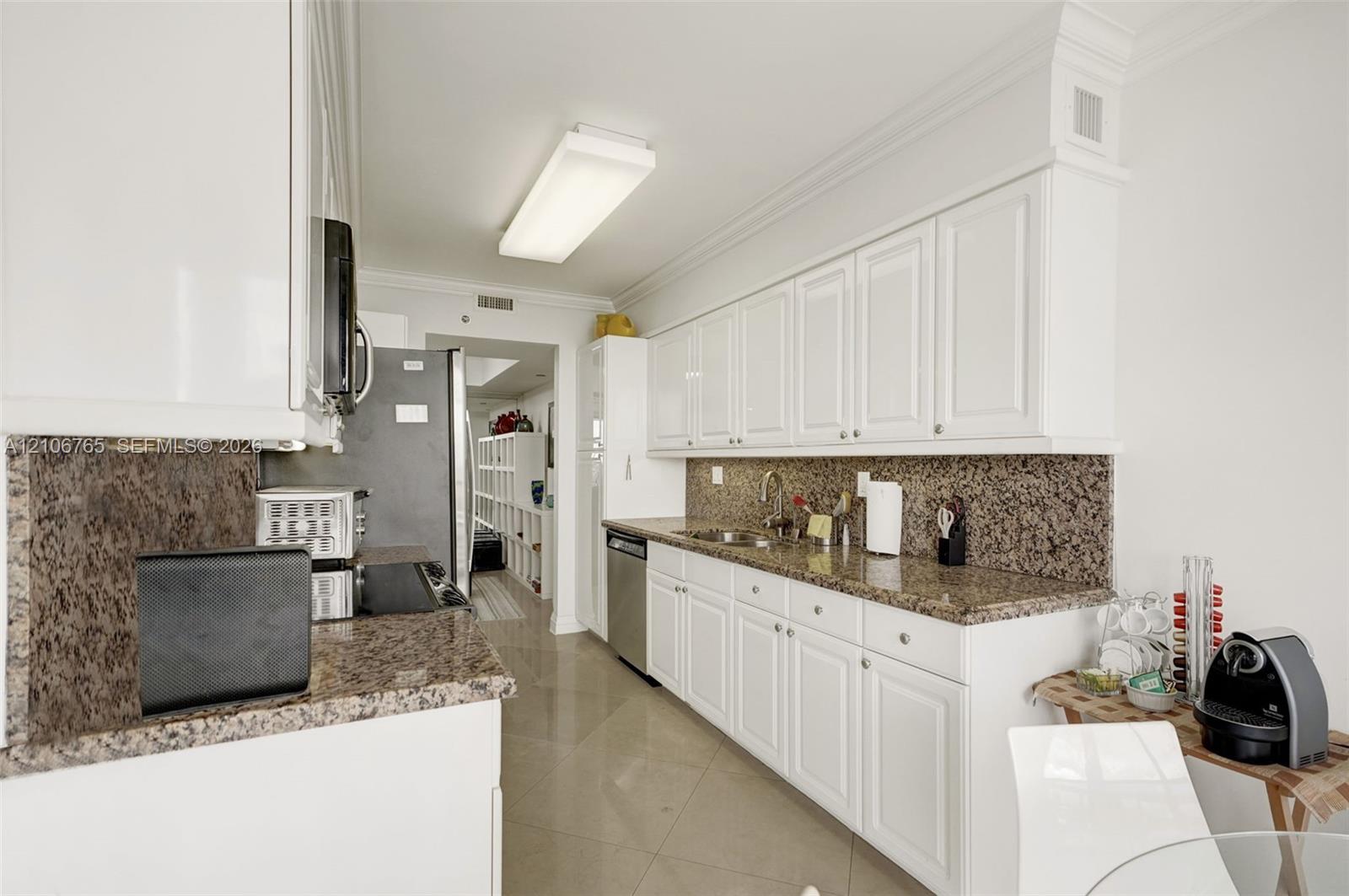 White cabinetry, stone-finish countertops, integrated stainless steel appliances.