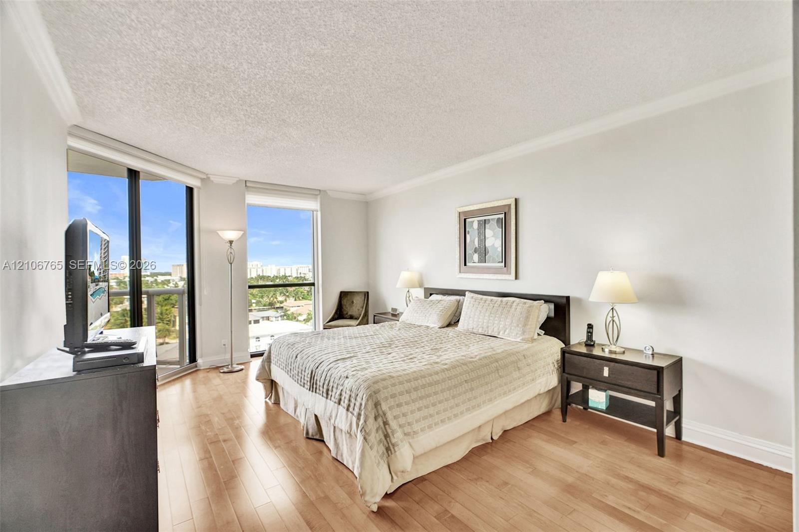 Main bedroom. wood floors, floor-to-ceiling windows.