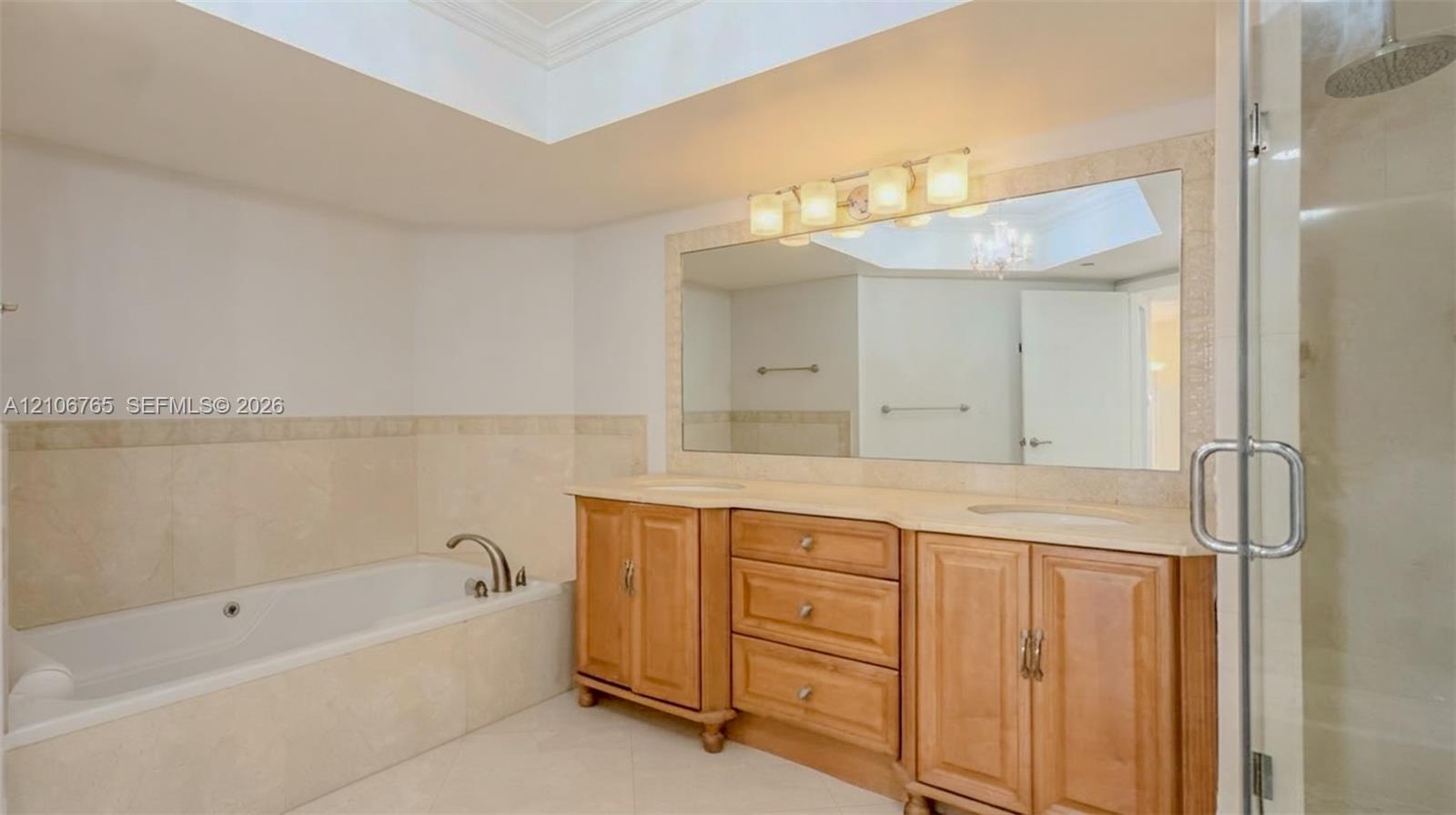 Main bathroom, a soaking tub with stone surround, a dual-sink vanity with wood cabinetry, and a glass-enclosed shower