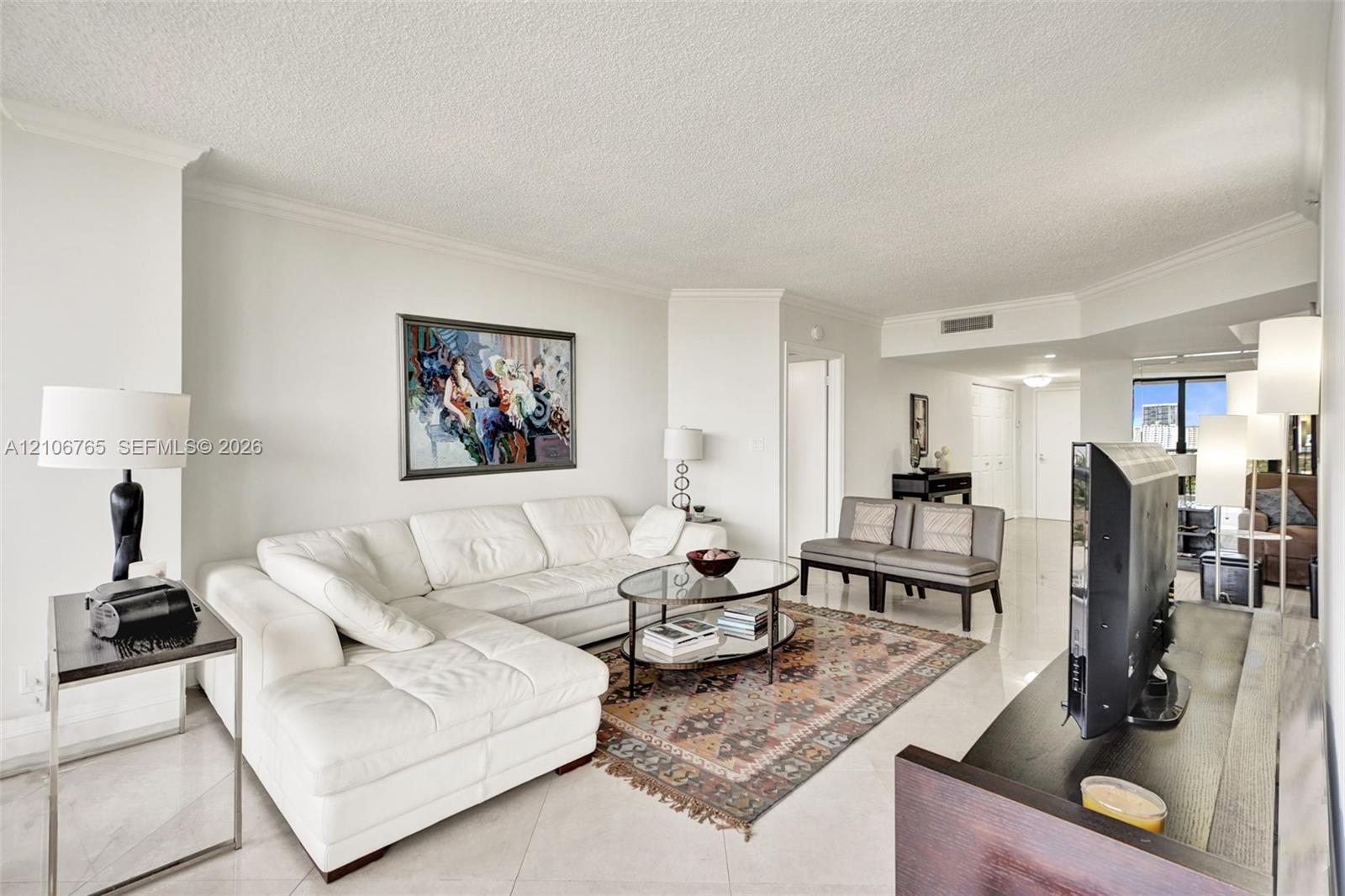 Open-concept living space, ceramic tiles, neutral wall tones.